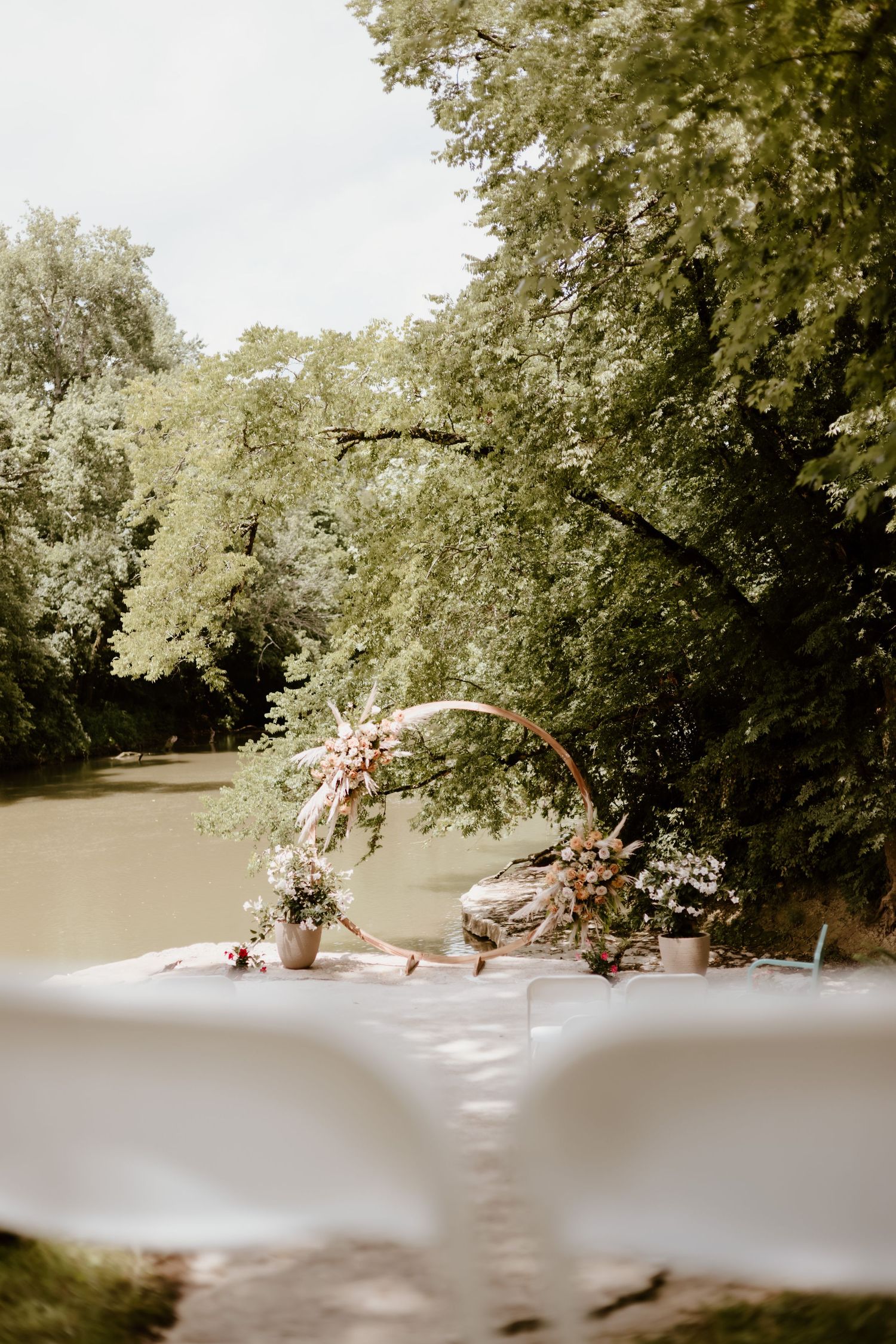 Ethereal outdoor garden setting with soft sunlight filtering through lush green trees and scattered decor elements.
