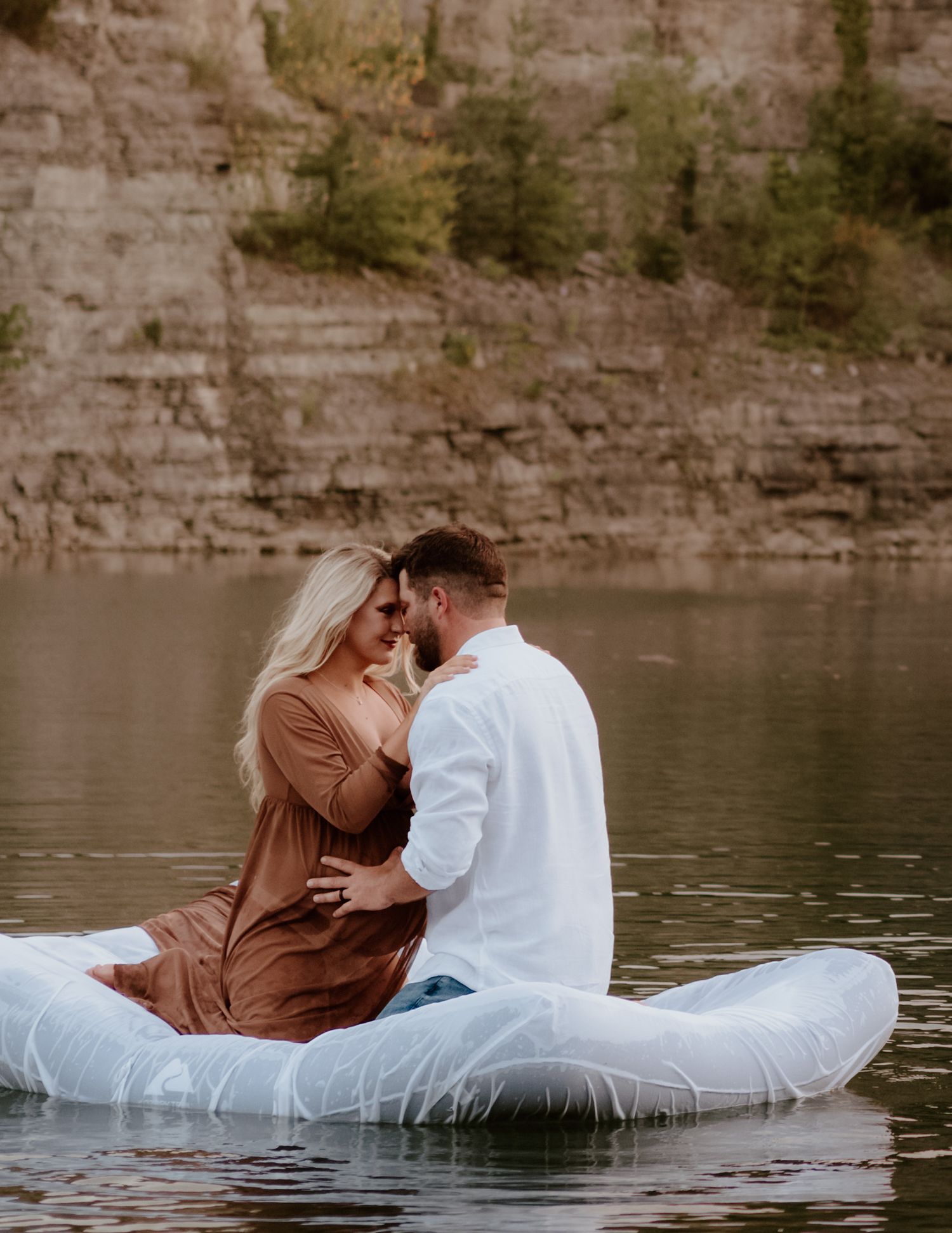 A romantic couple moment captured on a mattress floating on calm water.
