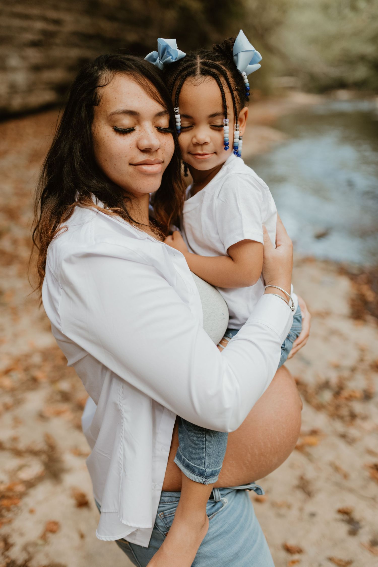 A tender moment between parent and child wearing matching white tops and blue bows.