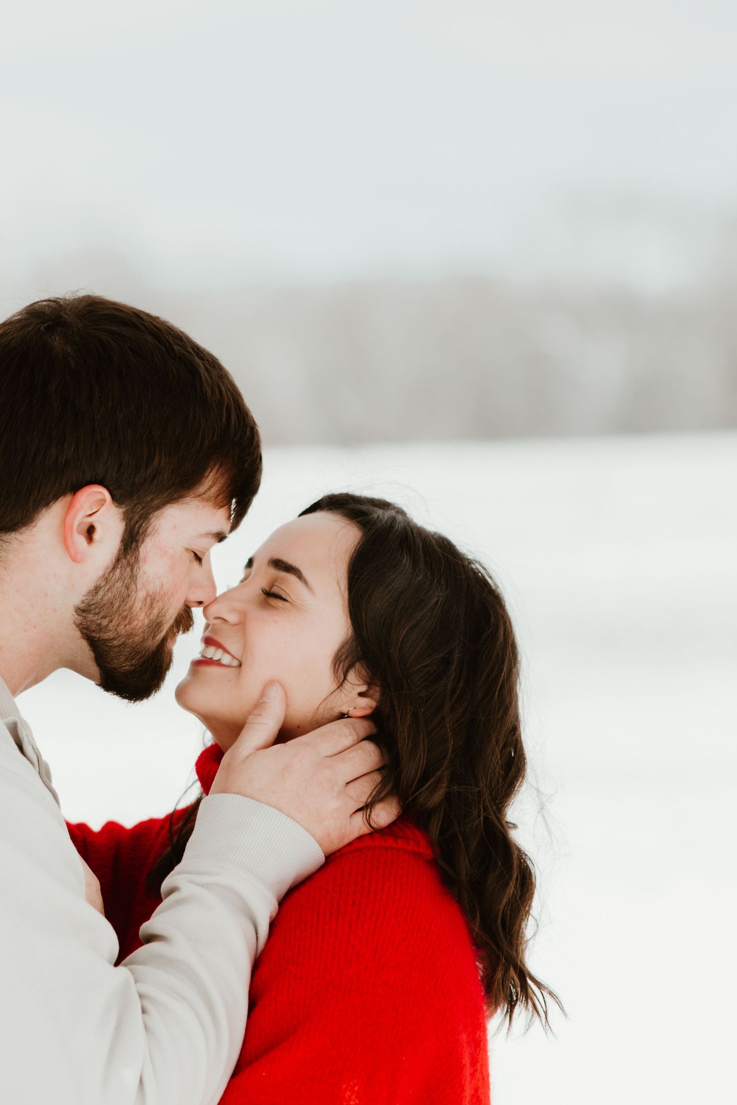 Intimate winter couple portraits with one person in bright red sweater.