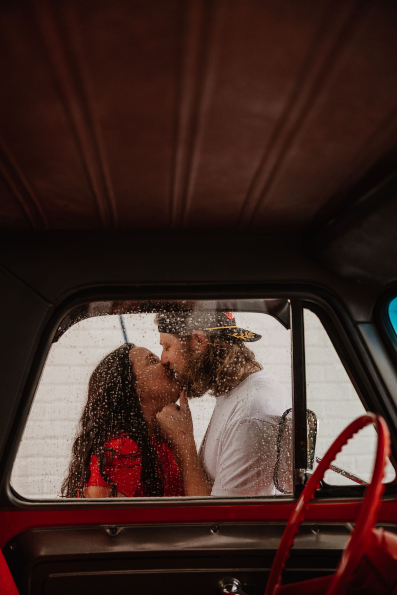 A romantic moment viewed through a rain-covered car window with a vintage aesthetic.