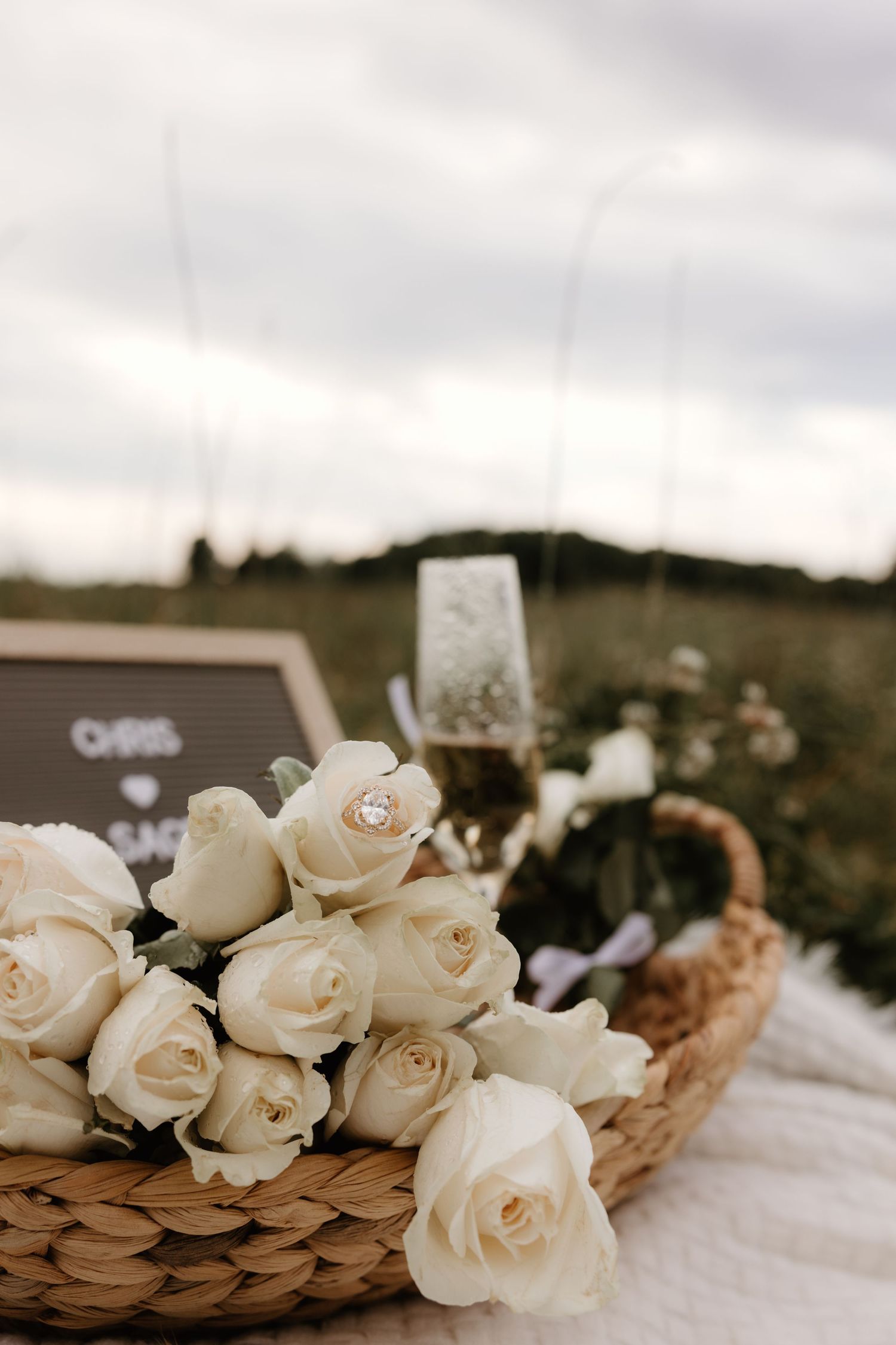 Romantic cream roses and dried pampas grass arranged on a white surface create an elegant rustic wedding centerpiece.