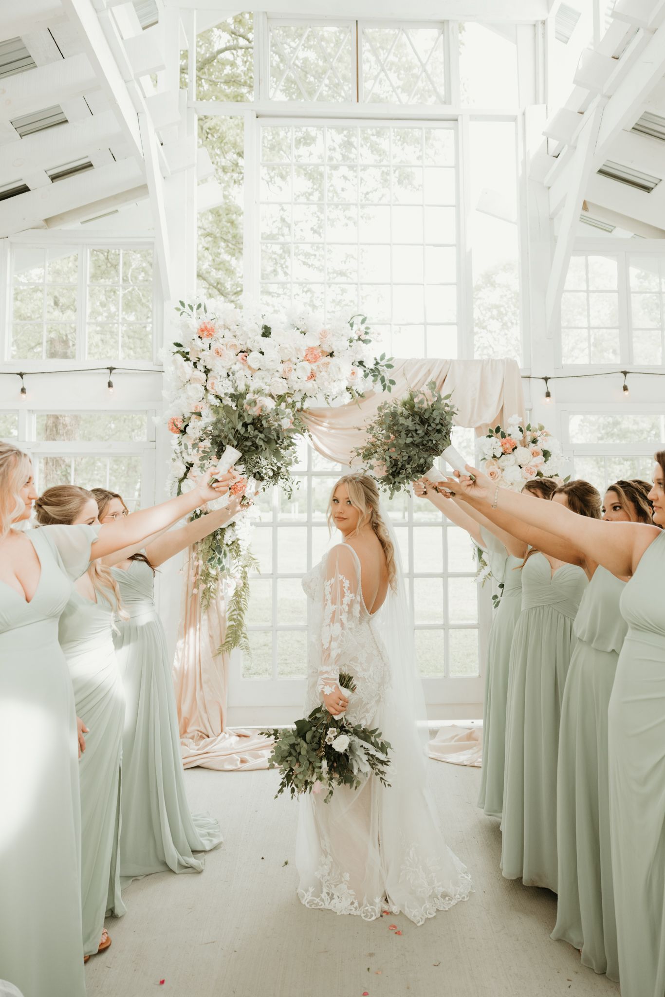 Wedding celebration in bright conservatory with bridesmaids in mint green dresses.