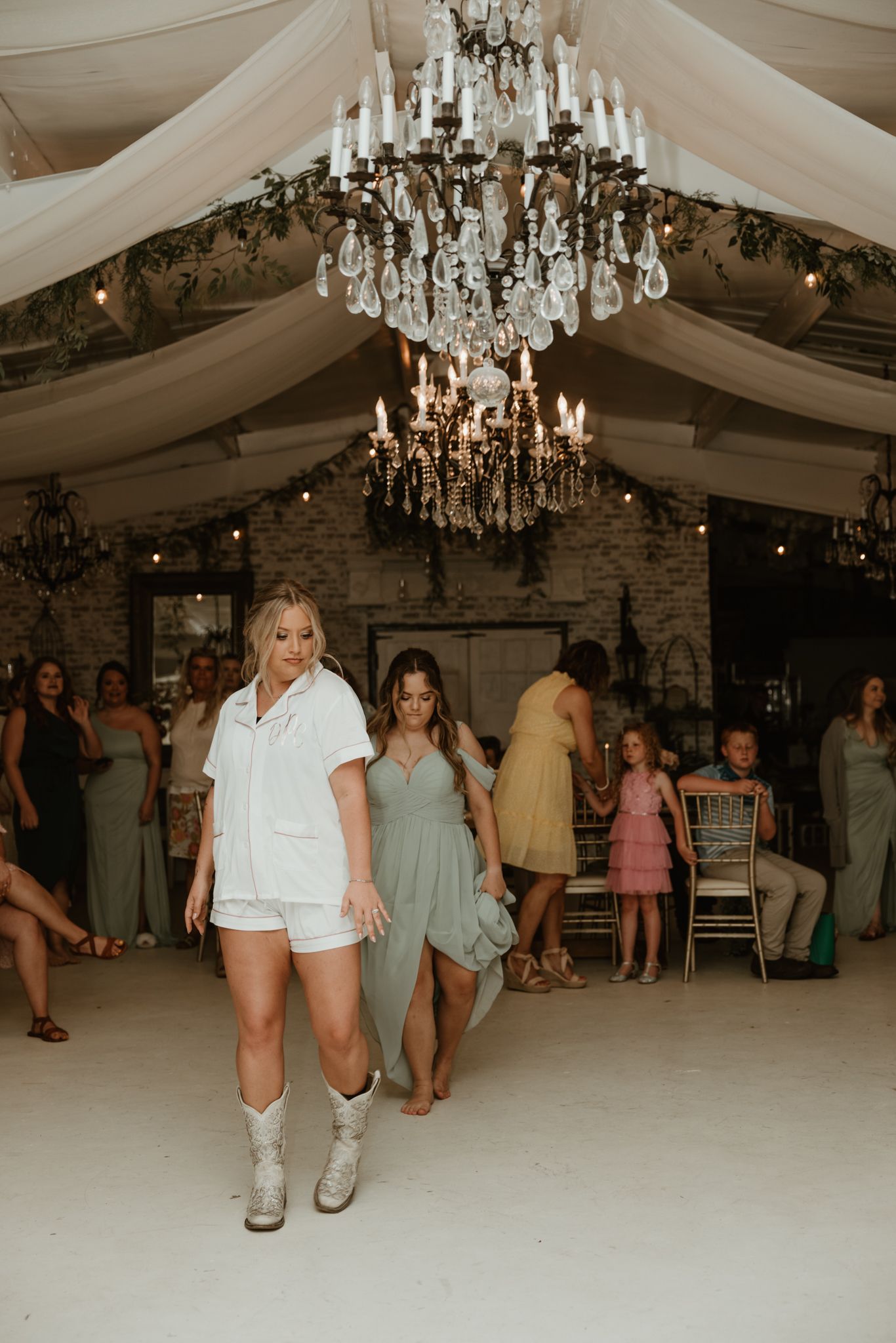 Reception venue decorated with crystal chandeliers and draped fabric creating an elegant atmosphere.