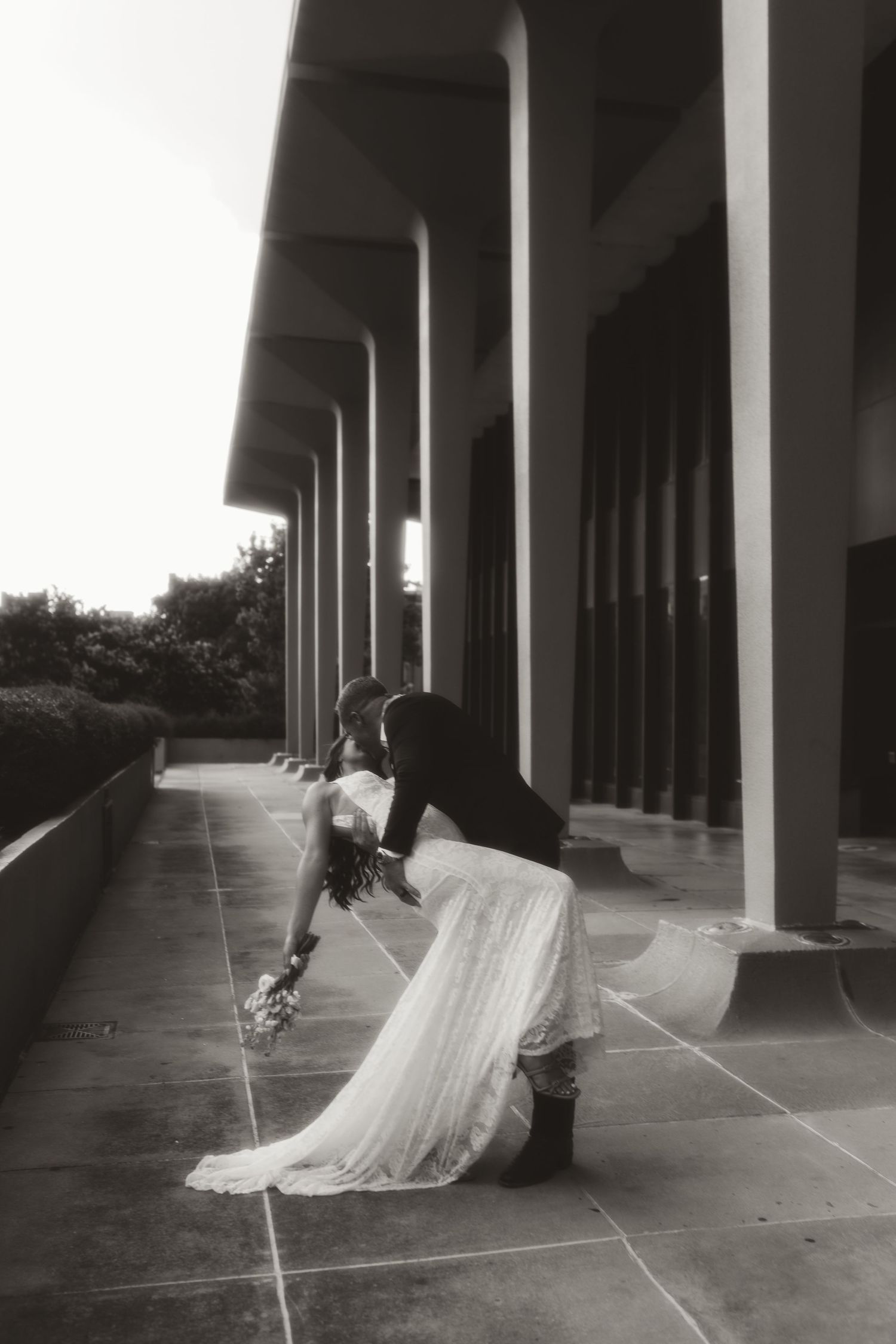 A sequence of black and white photos showing a couple dancing elegantly under a covered colonnade.