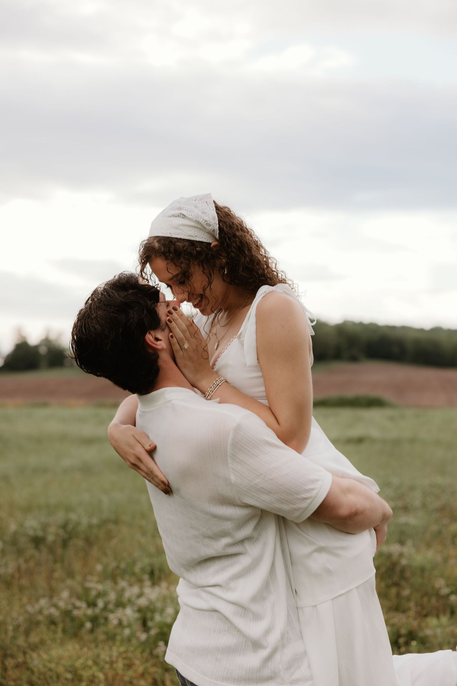 Romantic couple sharing tender moments in a natural field setting.