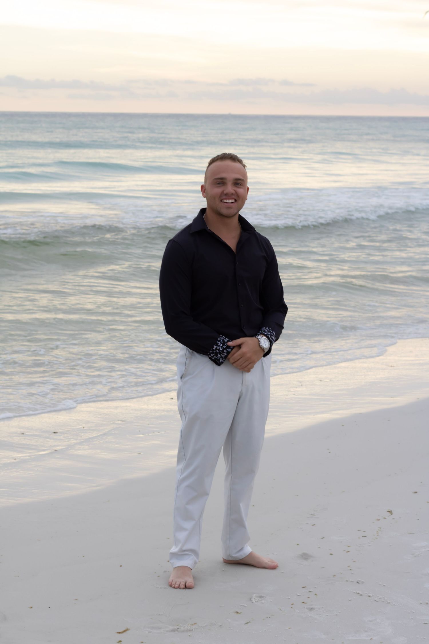 a male portrait on the beach in Panama City, Florida. the colors are pastel while he remains the focus