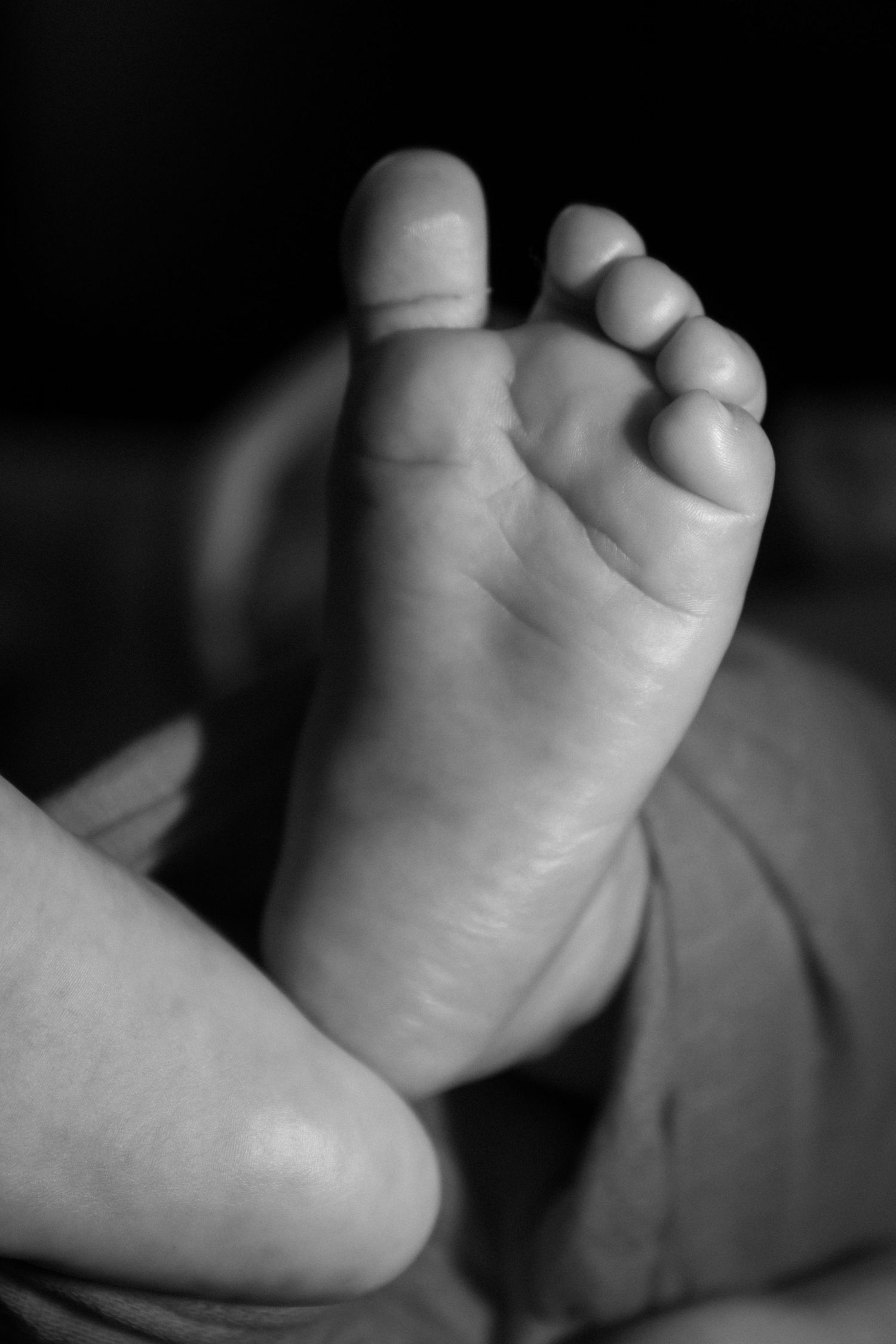 a black and white picture of a baby's foot. this will be cherished for a lifetime