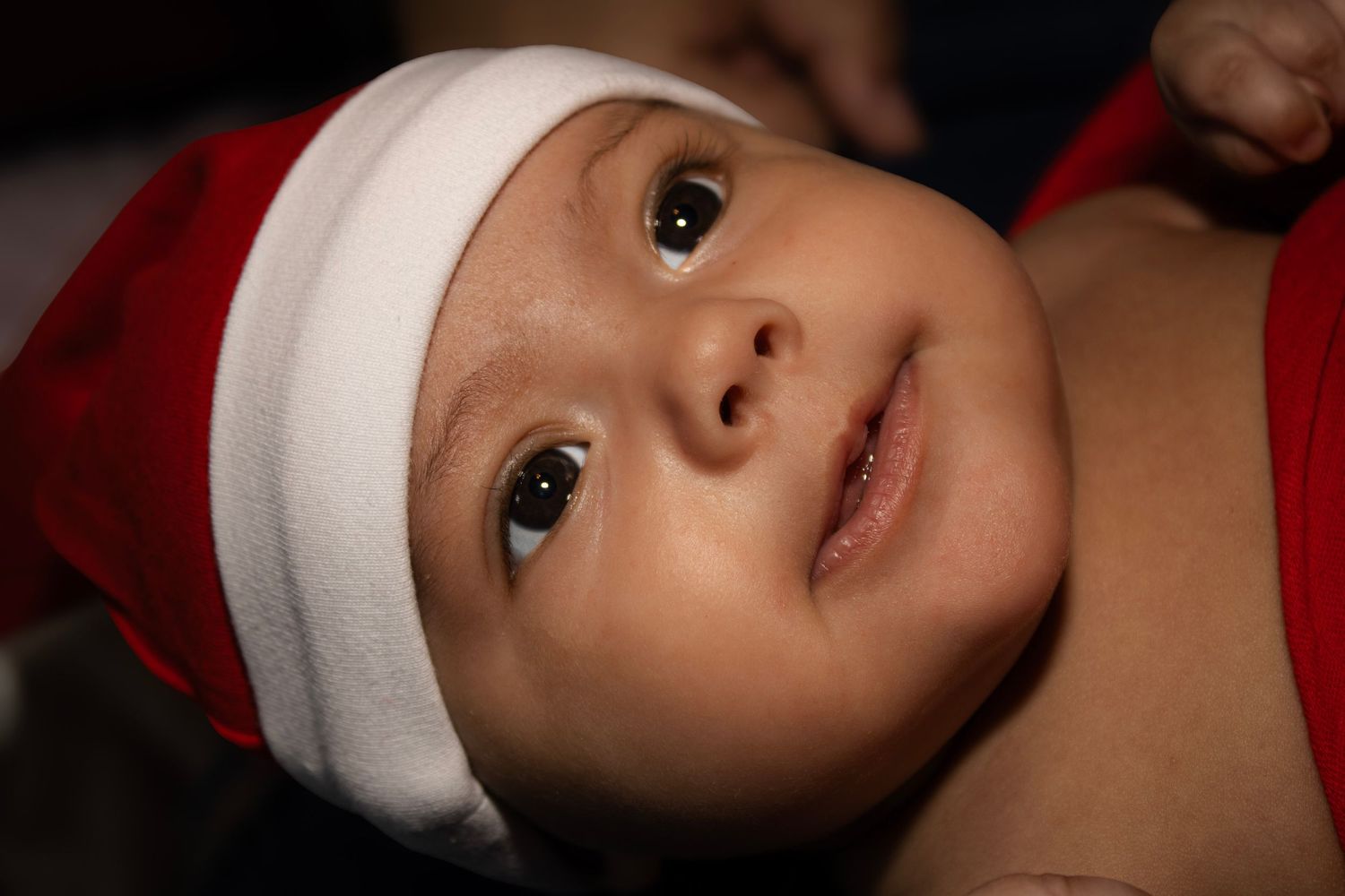 a baby getting her picture taken during December with a red and white outfit on