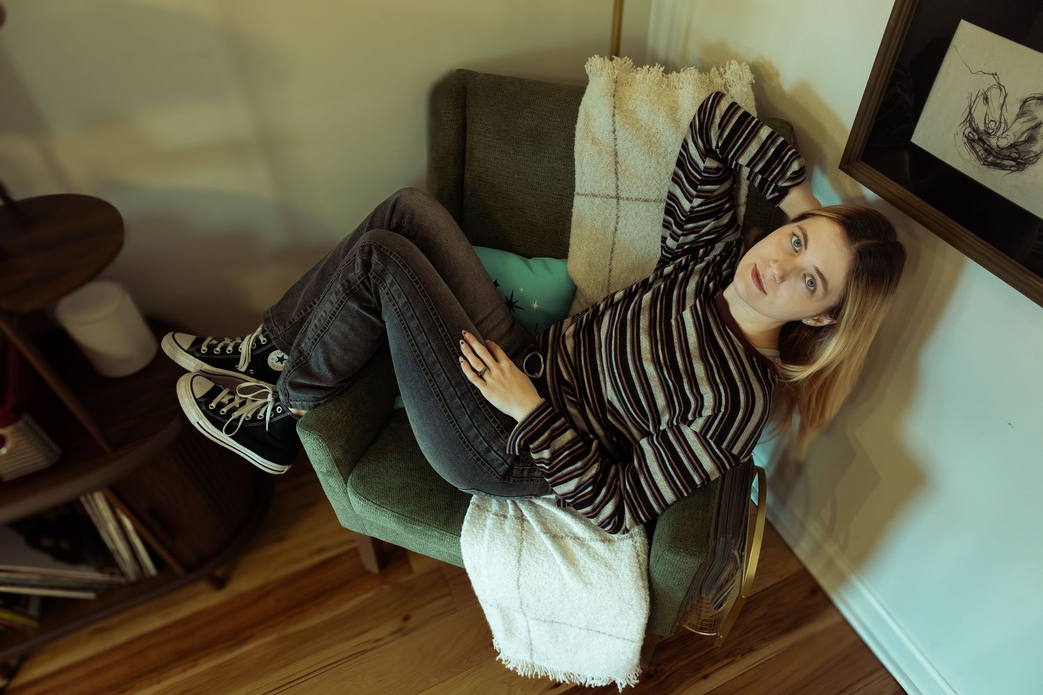 Artsy picture taken from above the model. There is a green hue to make the picture feel like twilight. She is positioned in a chair.