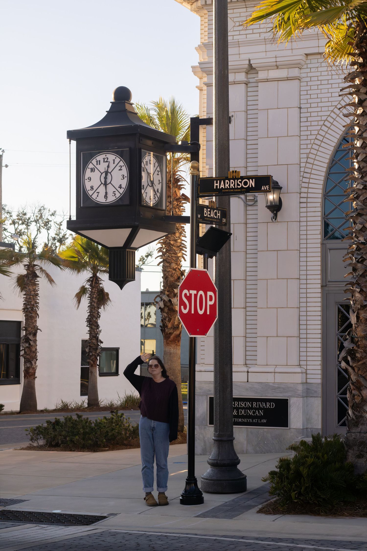 Downtown picture in Panama City, Florida. Model is standing next to the stop sign and under a clock. this picture showcases her looking off.