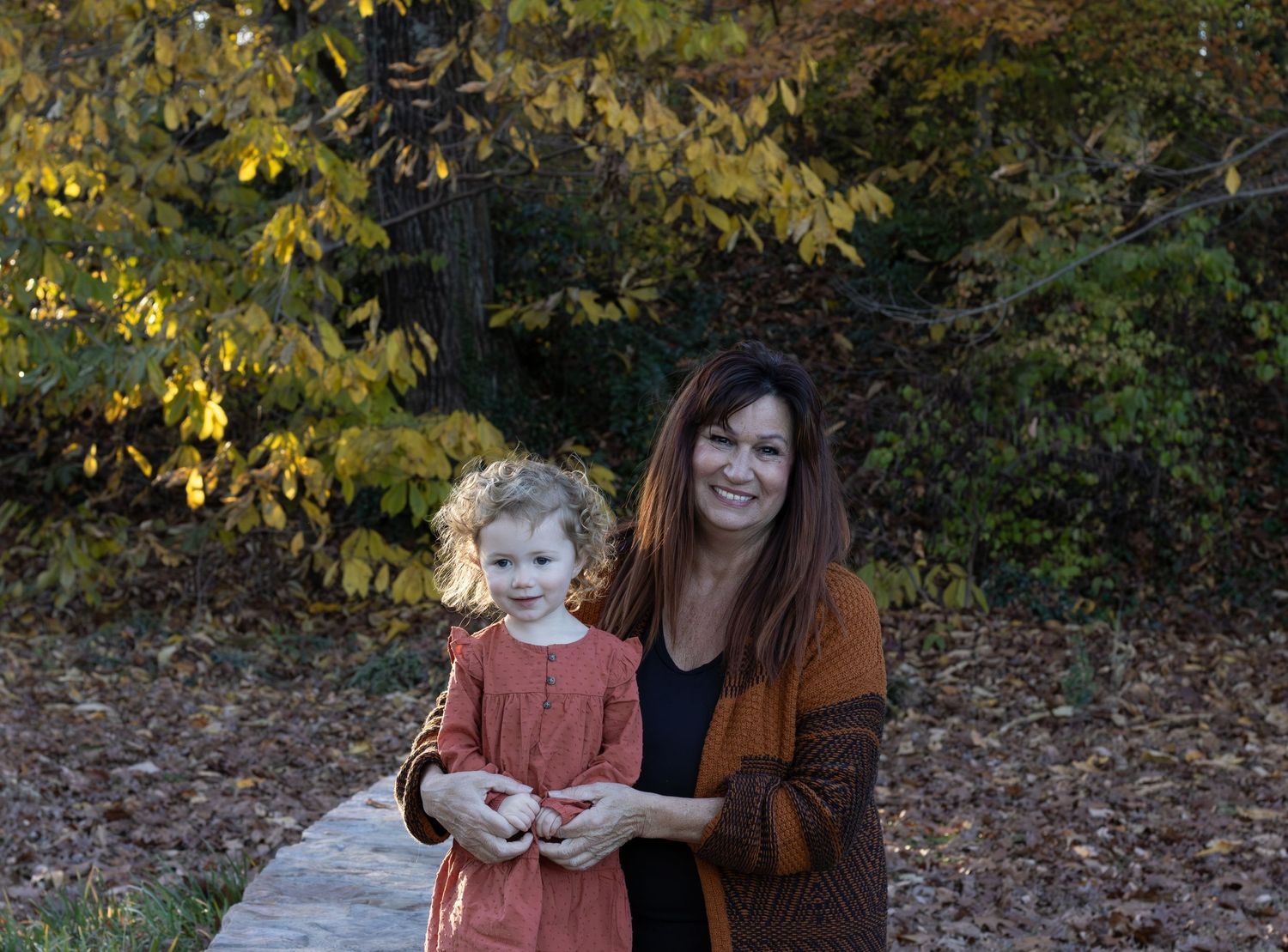 A grandma and granddaughter together sitting down. The lighting is making the photo feel cozy and warm.