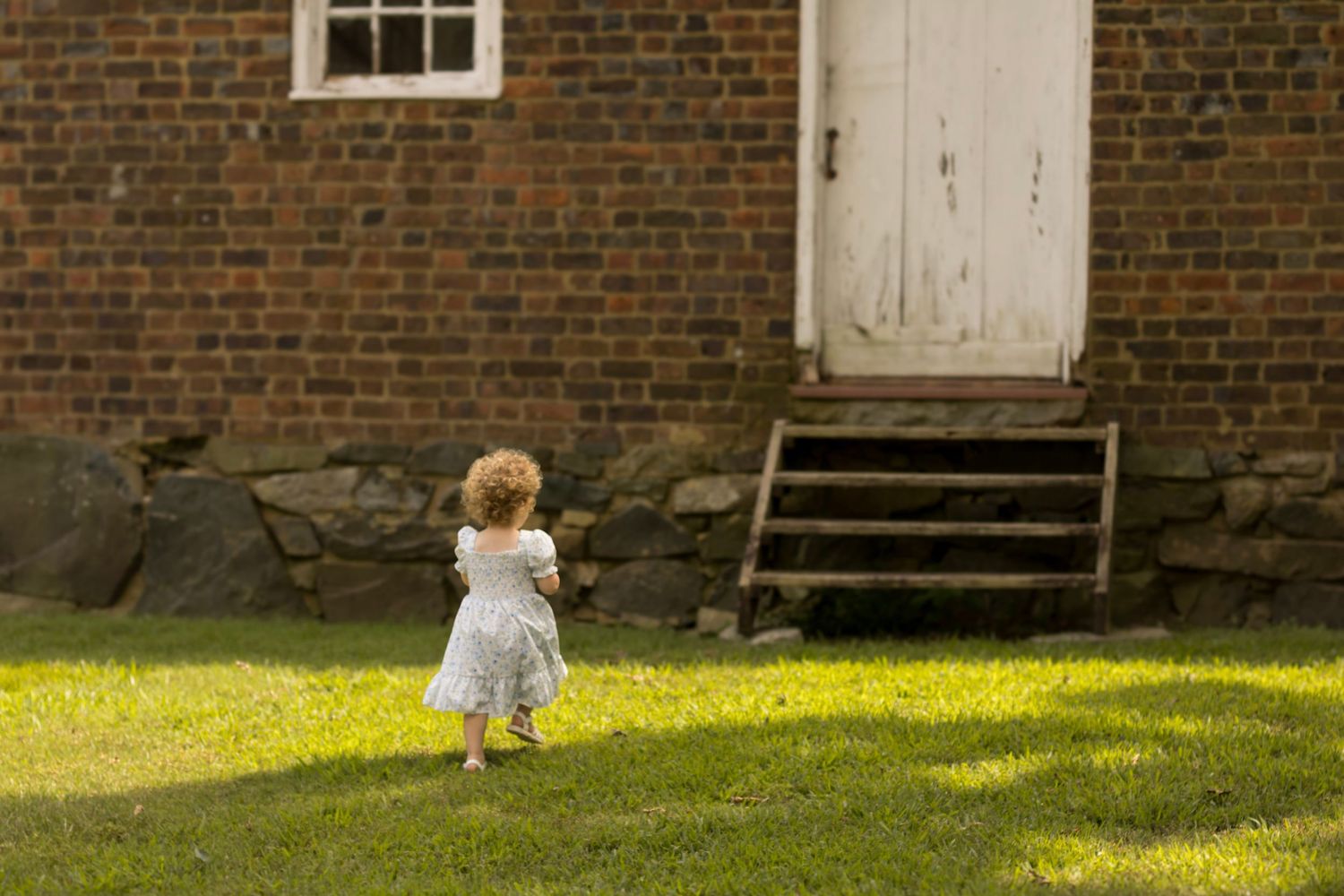 This photo is capturing a little girl running and acting like a toddler while getting beautiful pictures.