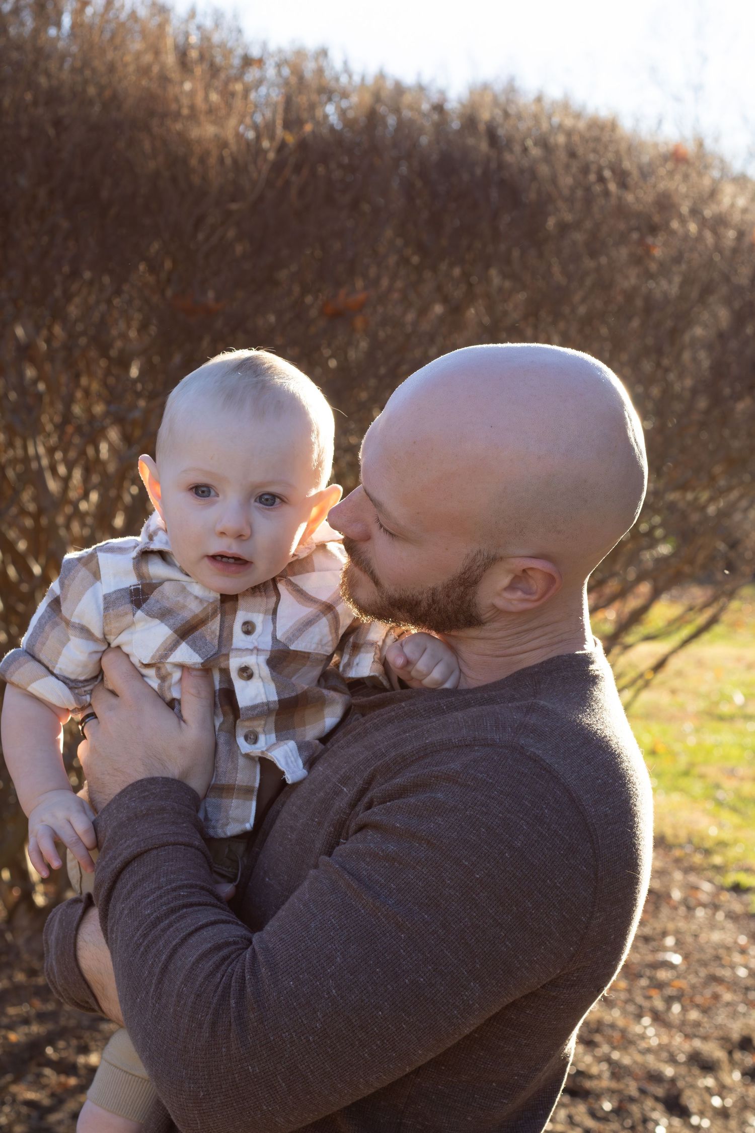 A father and son picture that is warm with the sun behind them. This gives a dreamy feeling to the picture. It is a warm and inviting moment