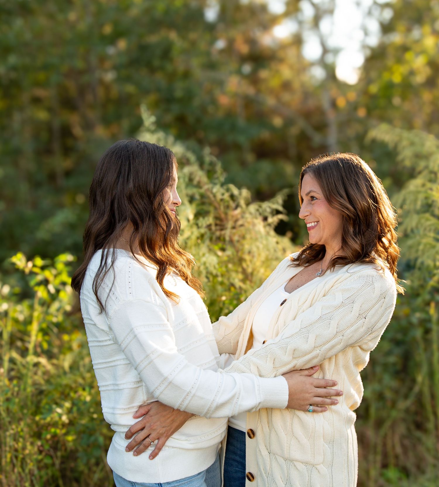 Mother and Daughter in white sweaters share a tender moment while standing together outdoors in warm sunlight- Rome GA