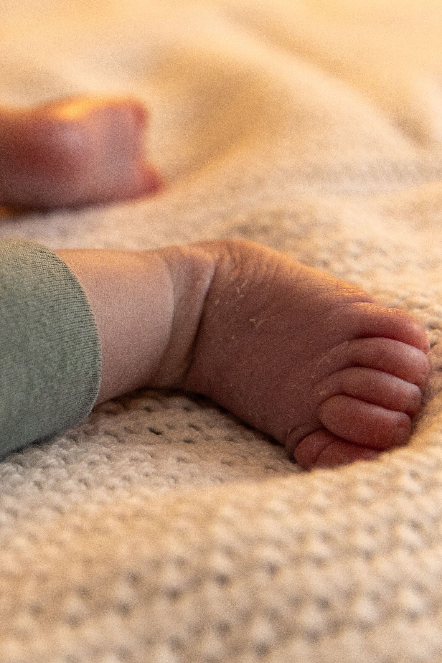 A close-up sequence of a small baby's foot touching and exploring a textured blanket surface- Rome, GA Jessica M Cooper Photography LLC