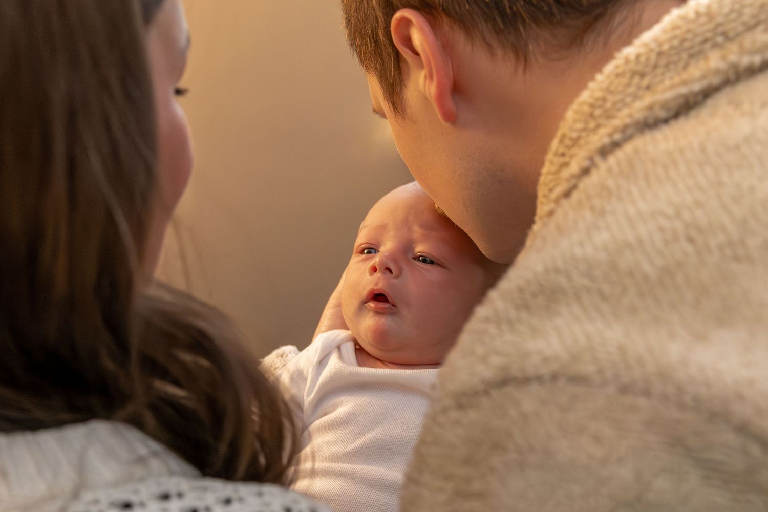 close up shot of father kissing infant's head in warm lighting- Rome, GA Jessica M Cooper Photography LLC