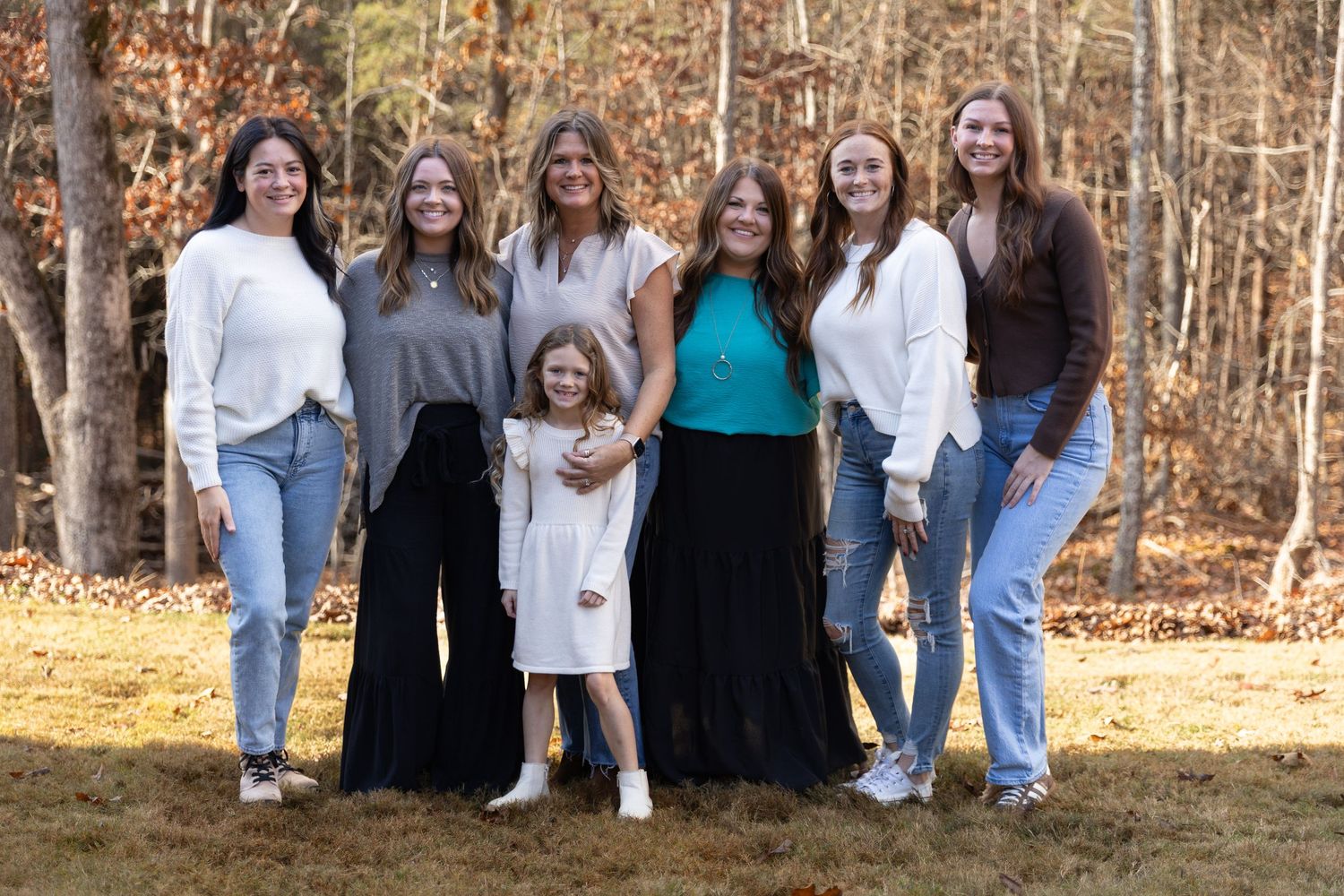A large family in casual attire pose together outdoors in a wooded autumn setting- Northwest Georgia Jessica M Cooper Photography LLC
