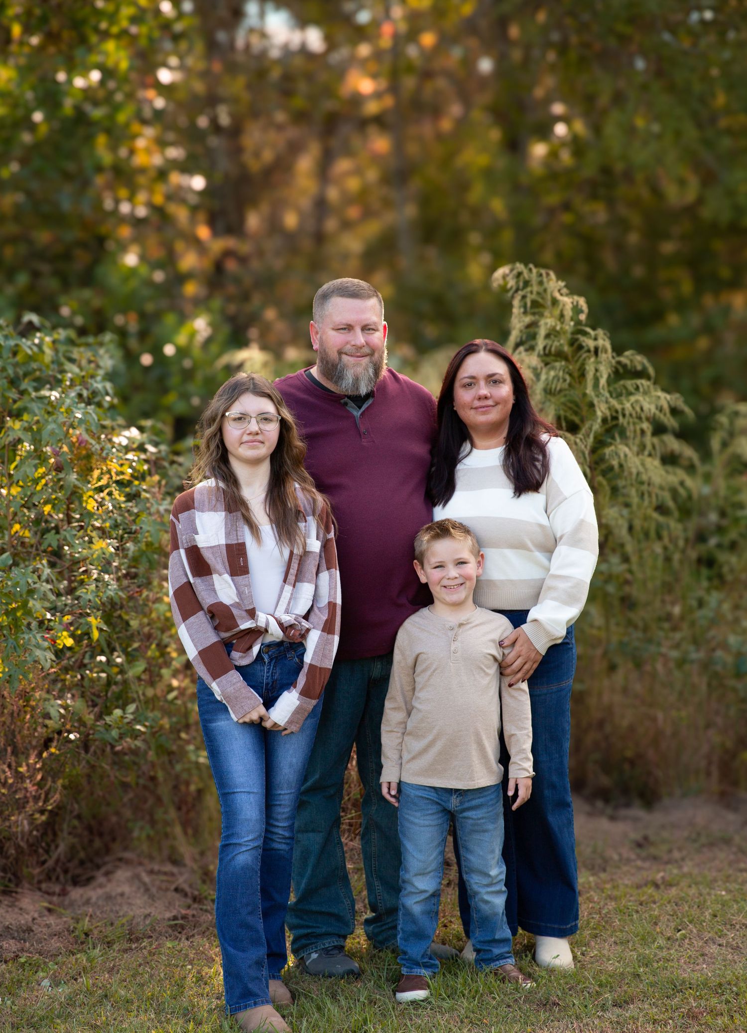 A family group stands together outdoors in casual attire during autumn-Northwest Georgia Jessica M Cooper Photography LLC