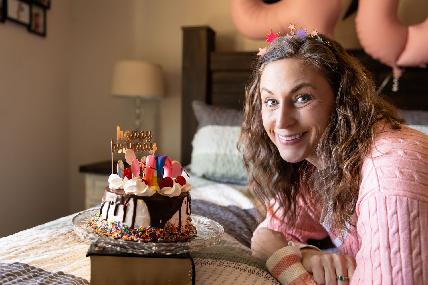 A birthday celebration scene with a decorated cake and pink decor in the background-Jessica M Cooper Photography LLC Rome GA