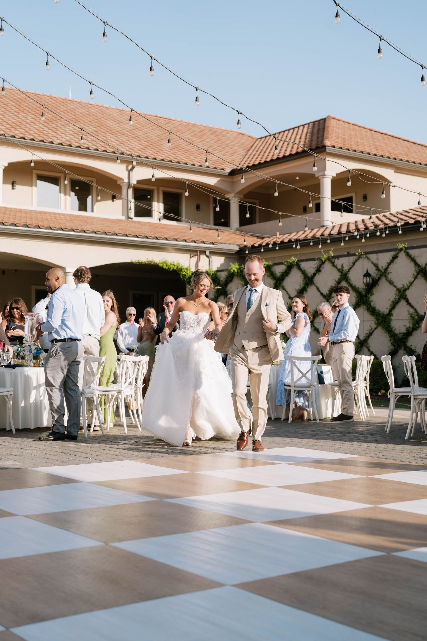 Wedding reception dance floor with string lights and guests celebrating.