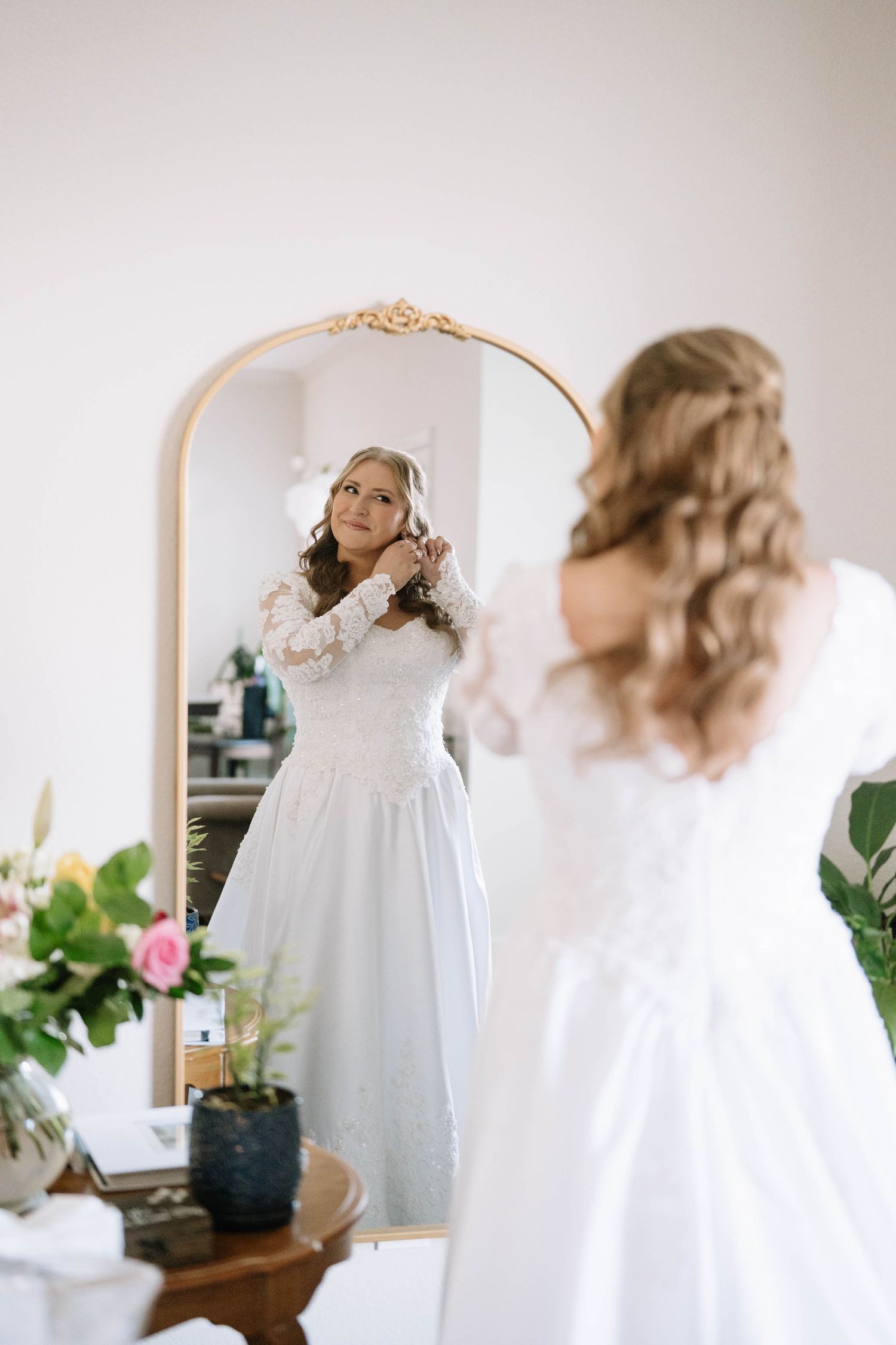 Getting ready sequence showing person in white robe preparing for special occasion in front of mirror.