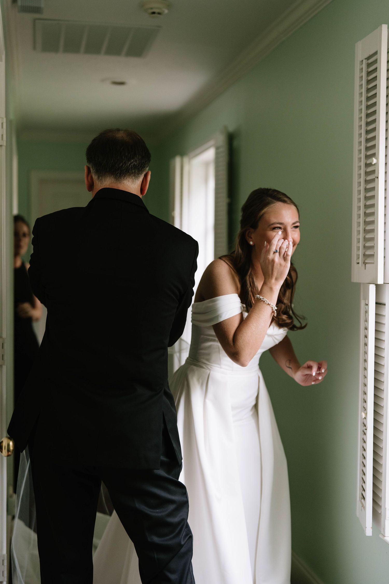 Intimate wedding moments captured in a bright hallway with natural lighting.