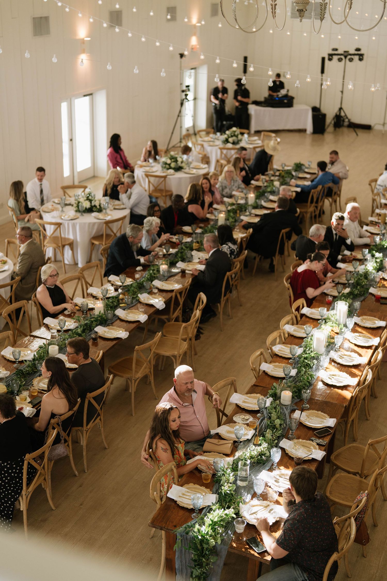 Wedding reception venue with elegant table settings and guests enjoying the celebration.