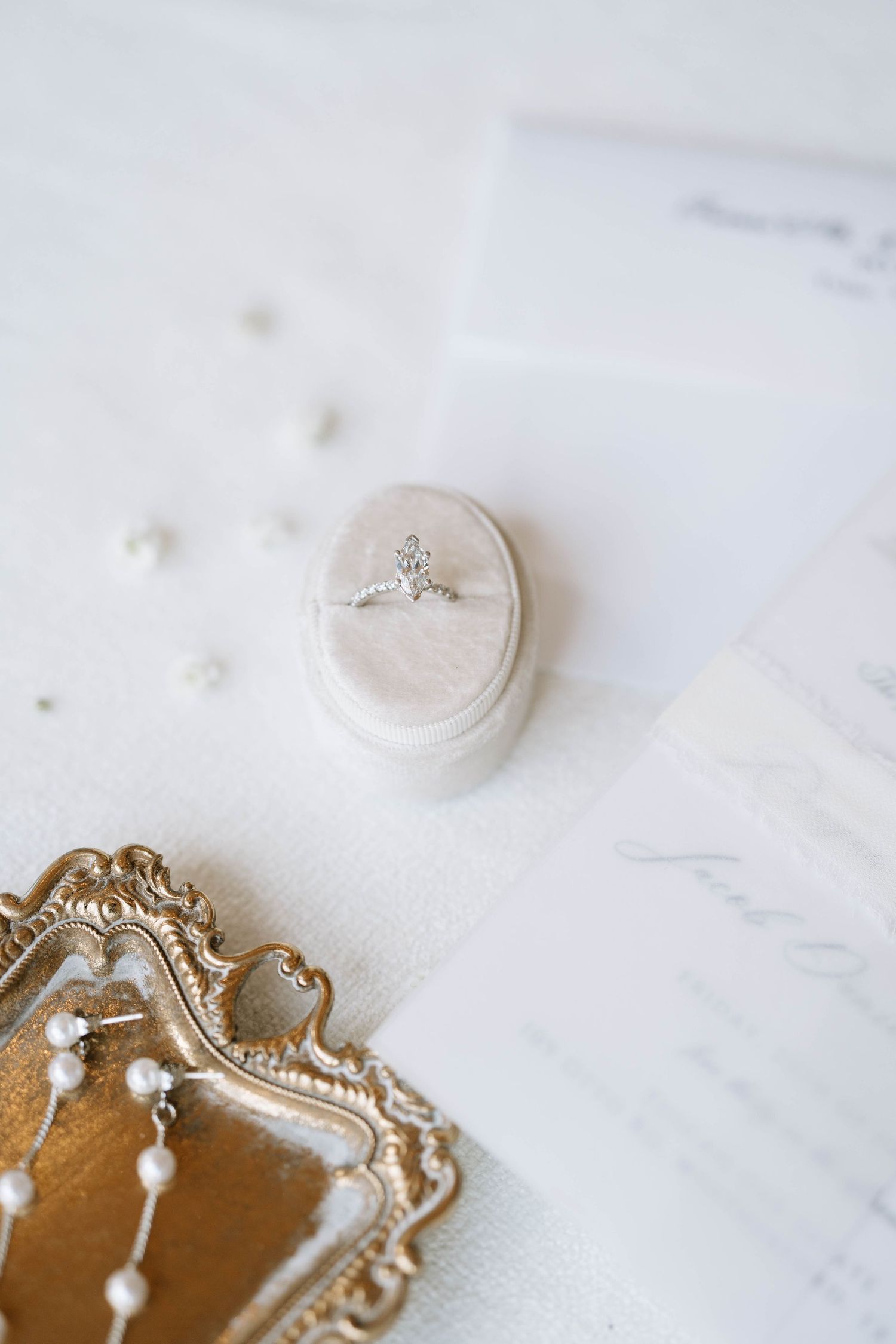 Vintage gold frame with wedding rings on white marble surface.