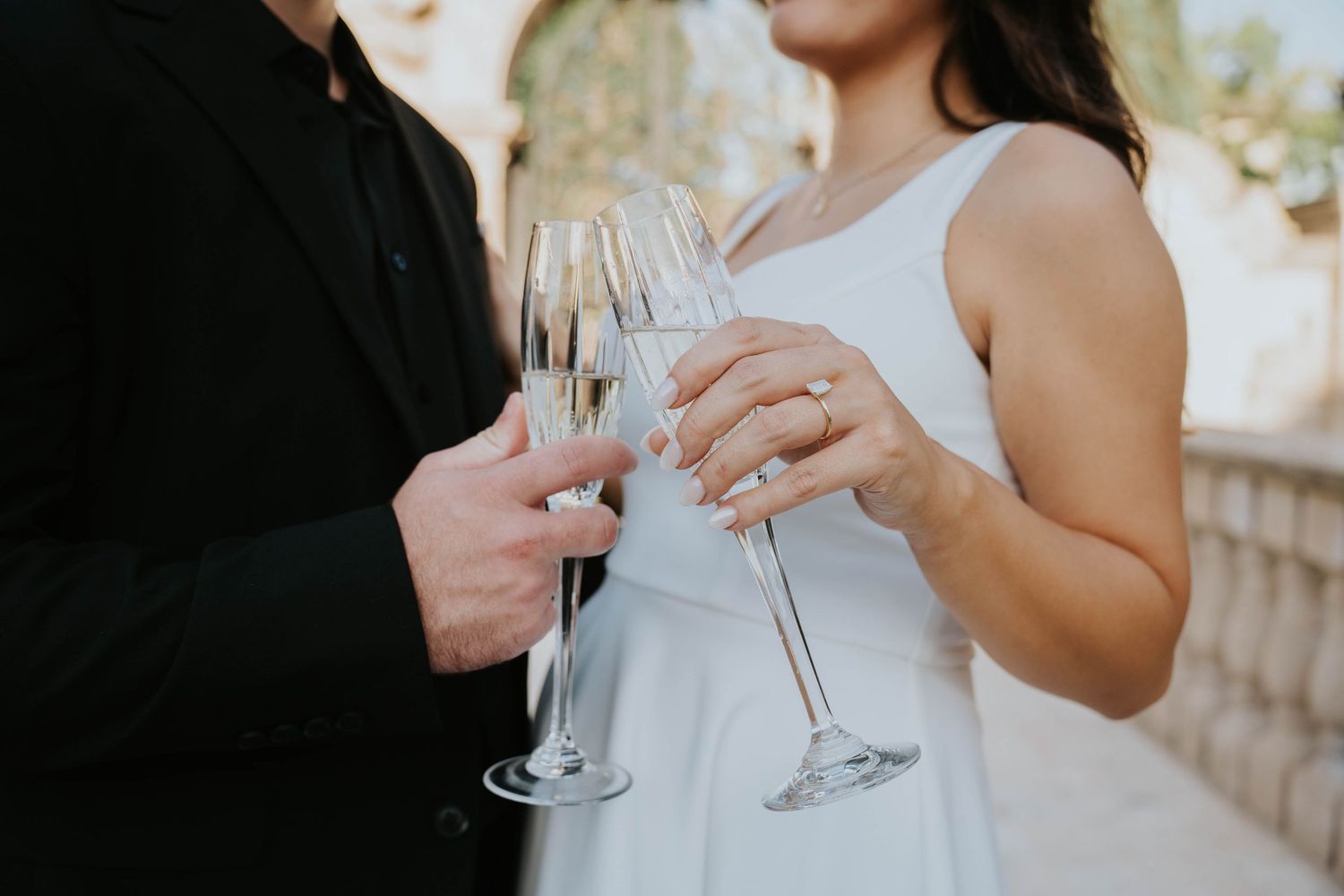 Close-up of hands holding champagne glasses during celebration.