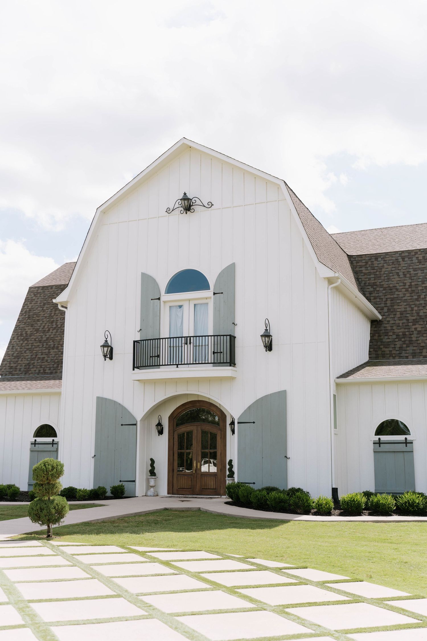 Modern white barn wedding venue with elegant architectural details and stone accents.