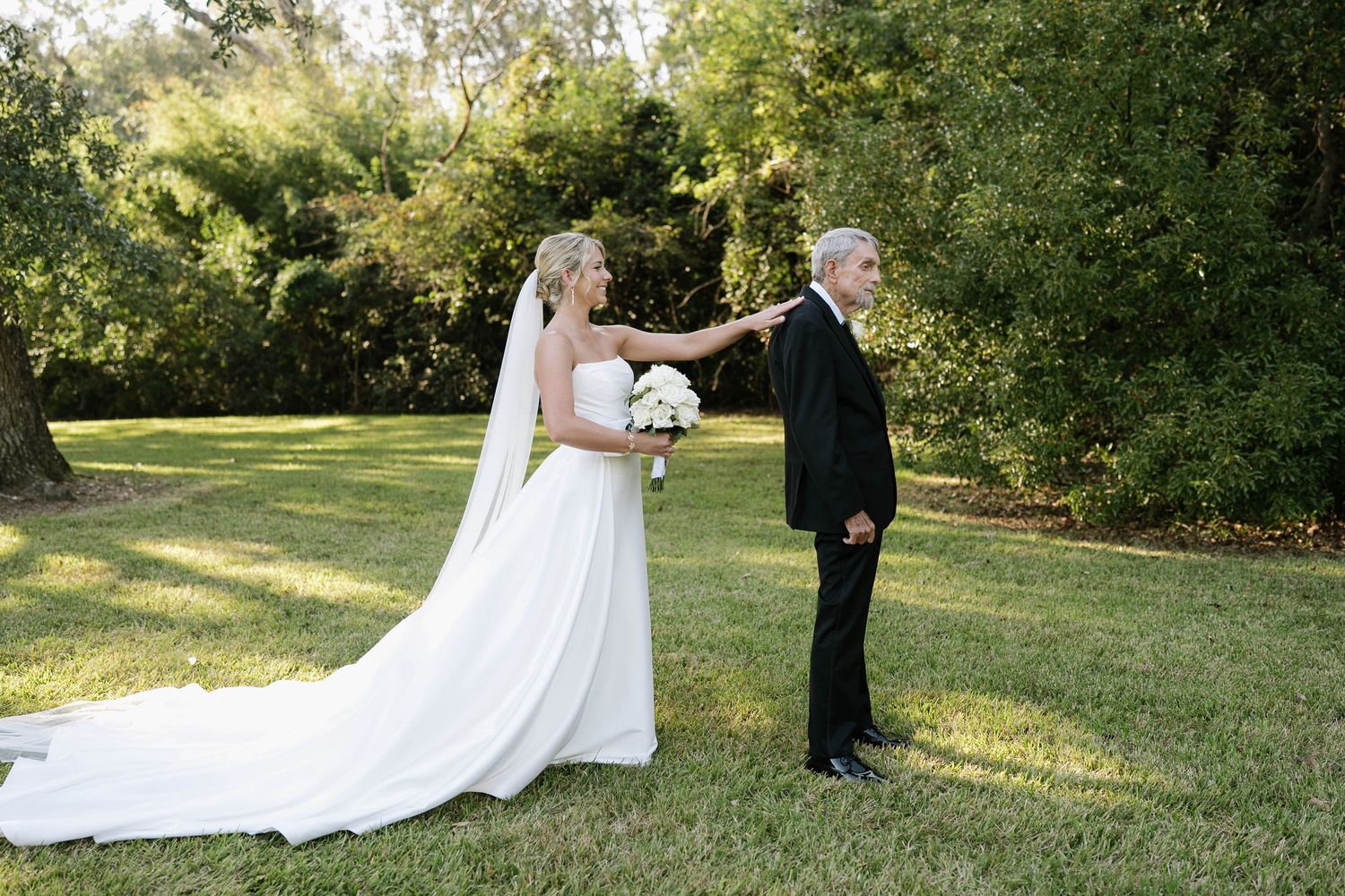 Couple poses for a portrait on their wedding day in a lush garden setting.