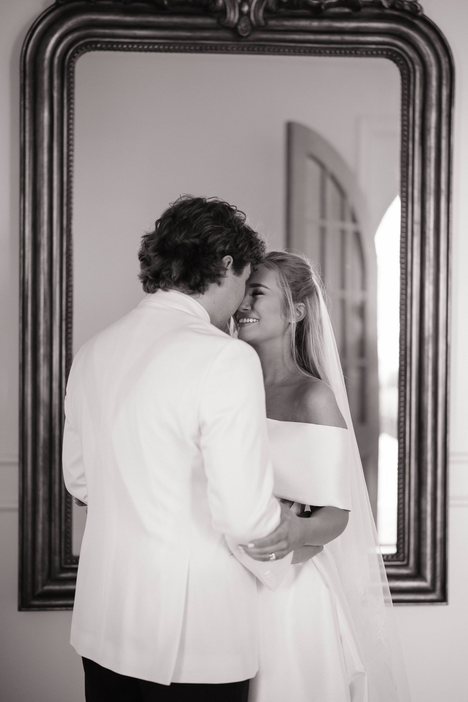 Black and white wedding moments captured through reflections in ornate mirrors.