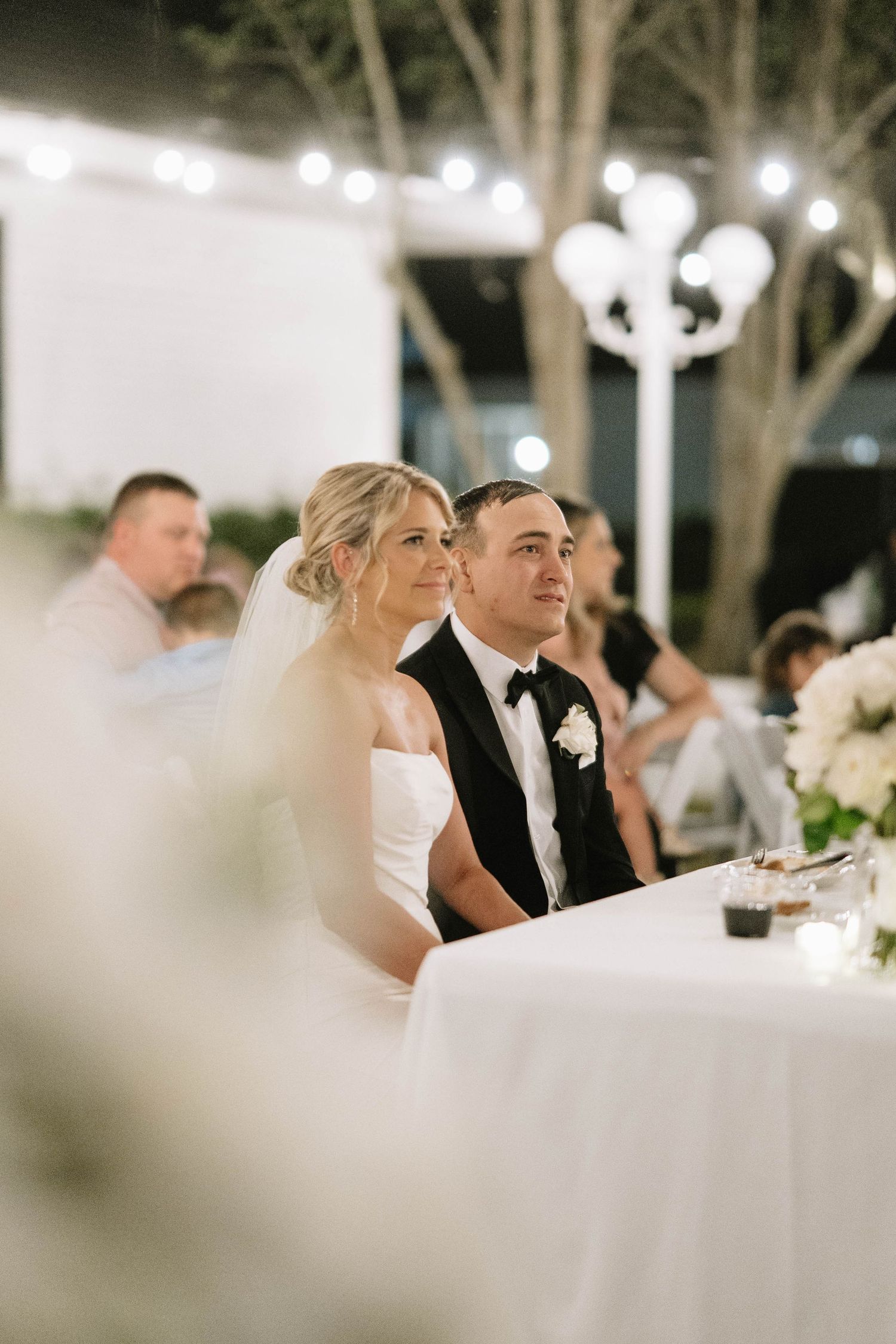 Reception scene with elegant table settings and string lights creating a romantic atmosphere.