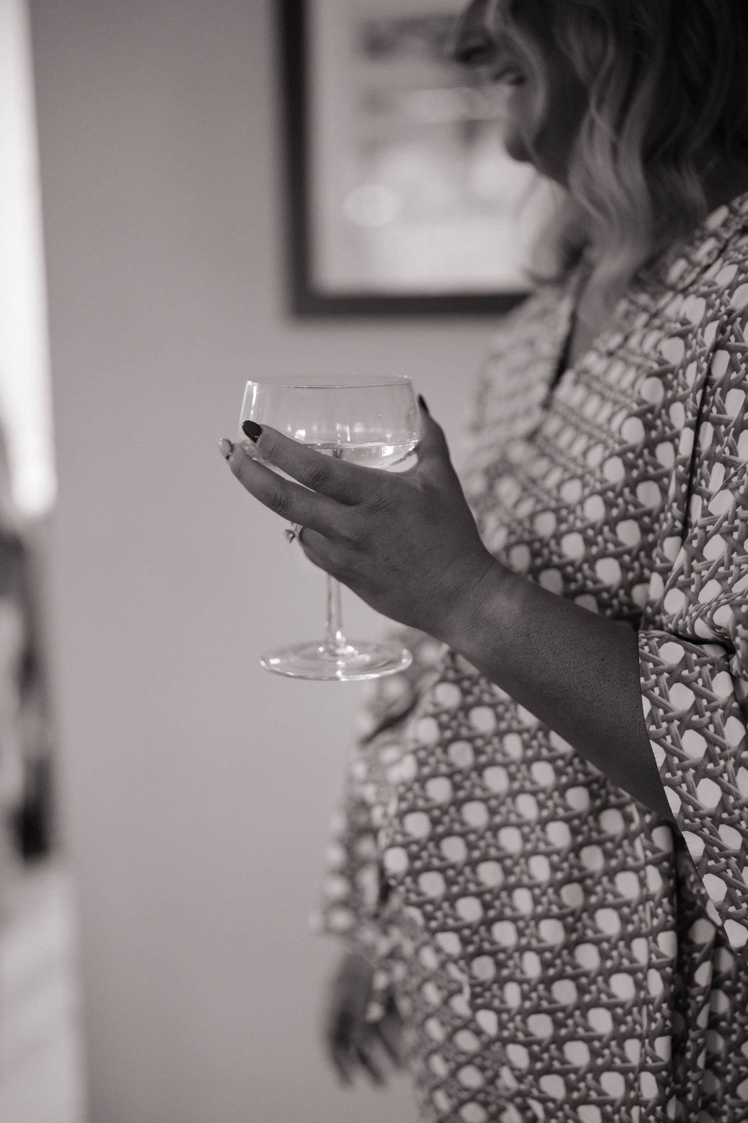 Hands holding champagne glasses in black and white photography.