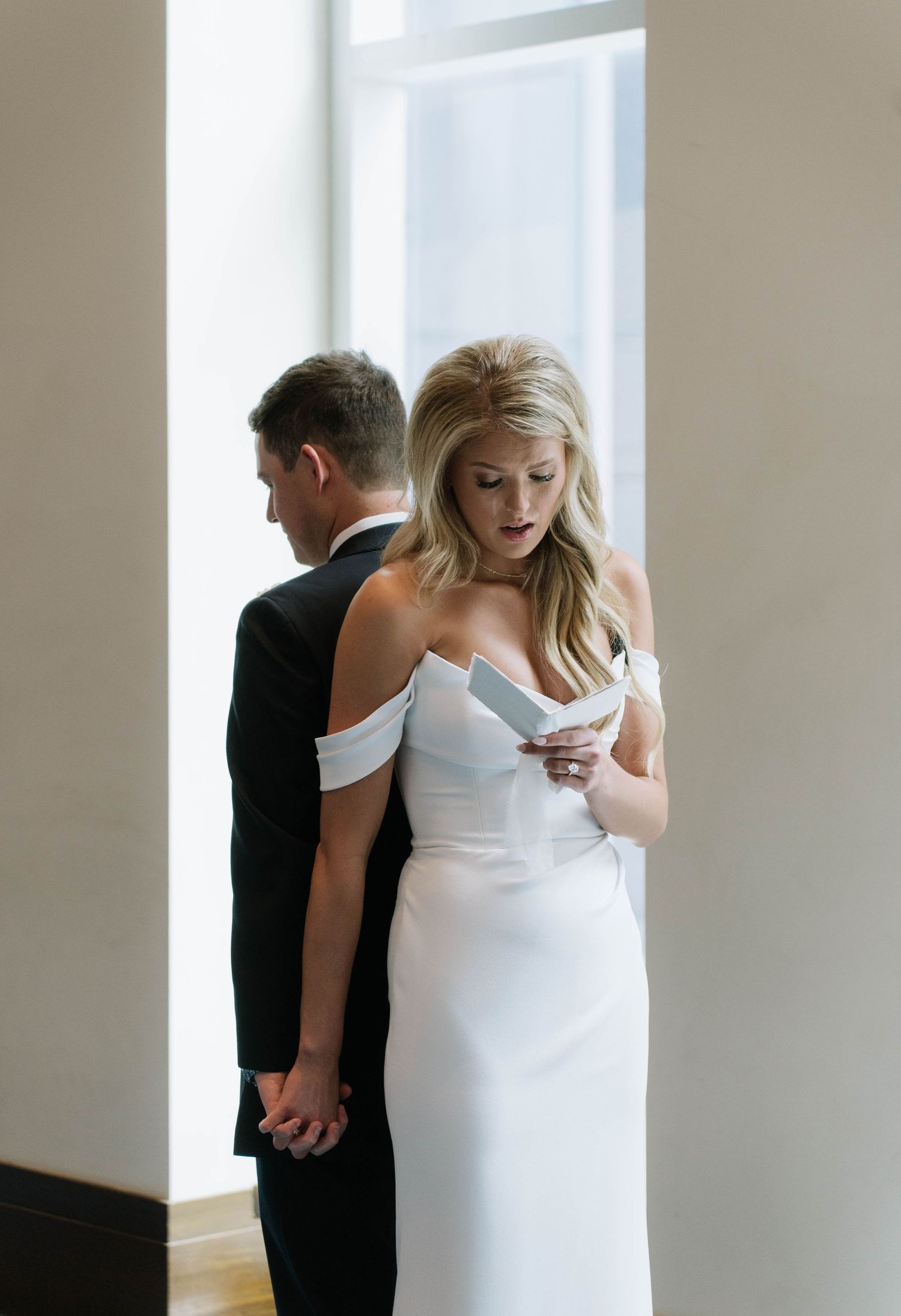 Intimate first look moment between couple in white dress and black suit.