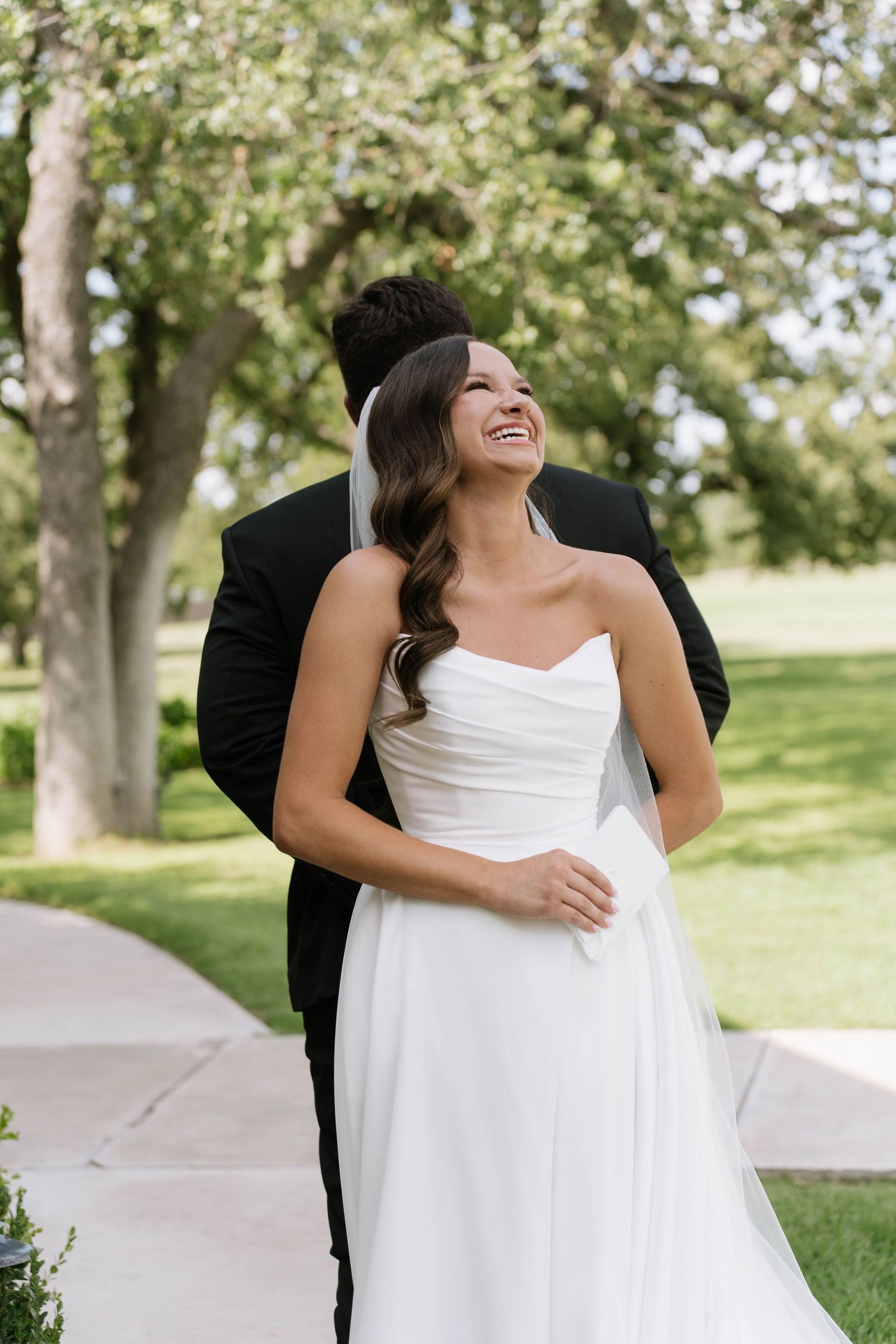 Joyful wedding moment captured outdoors with couple in formal attire.