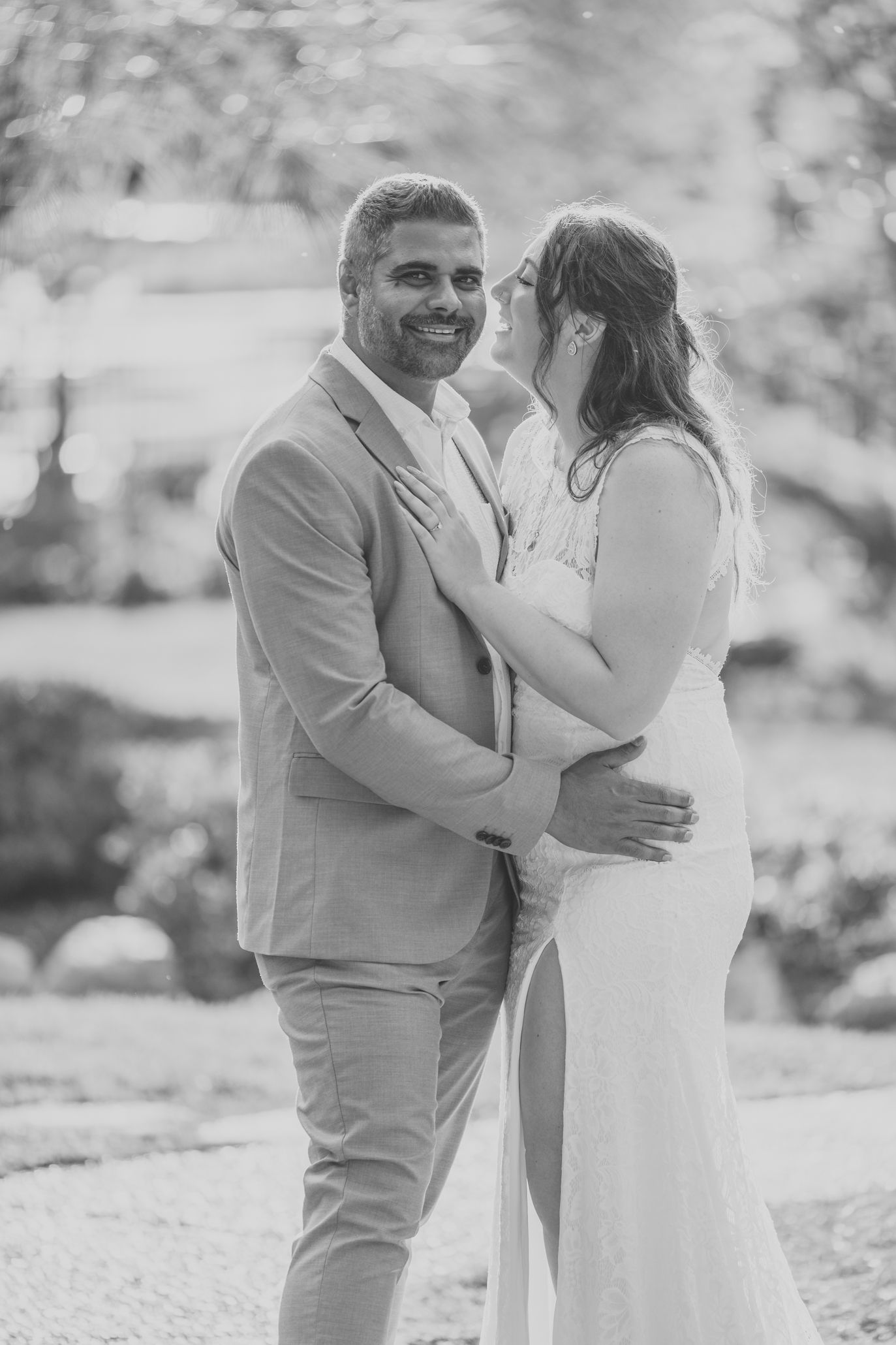 A couple embraces outdoors in a romantic photoshoot with soft lighting and natural scenery.
