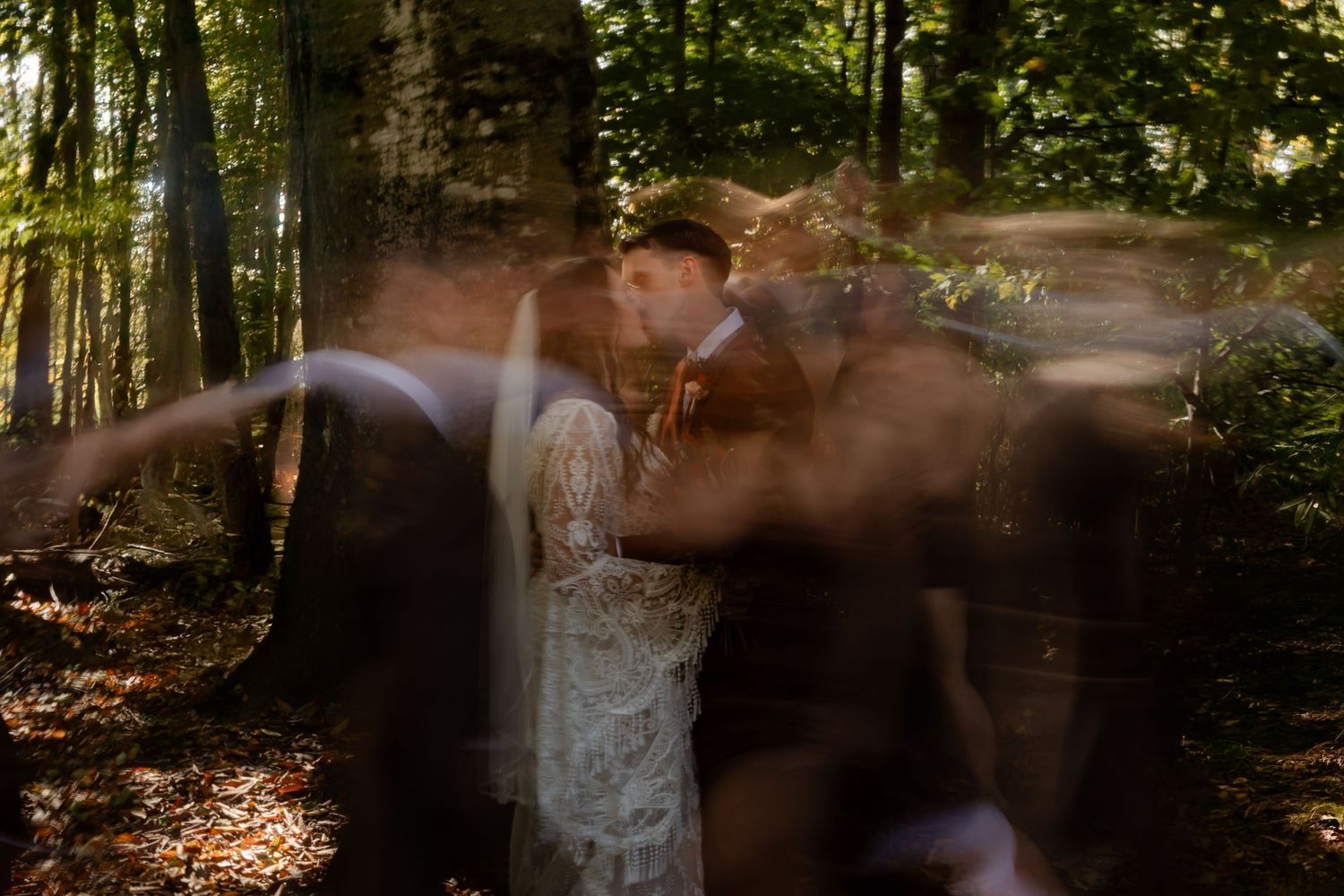 Artistic motion blur photo of a couple embracing in a forest setting.