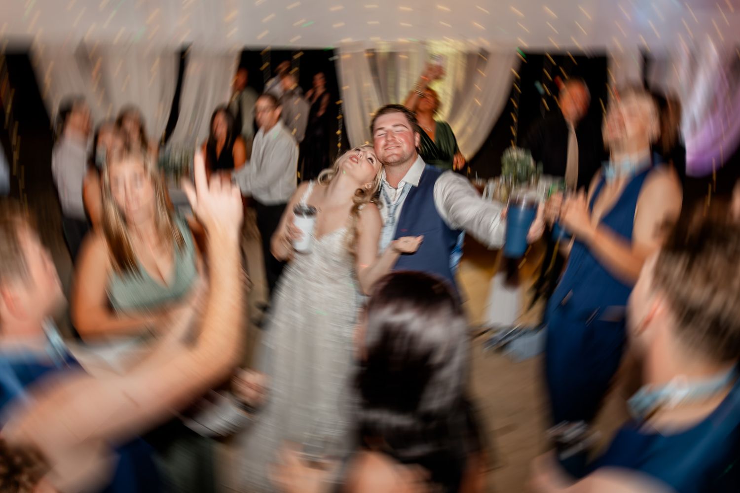 Energetic crowd dancing and raising hands at a celebration party with motion blur effect.