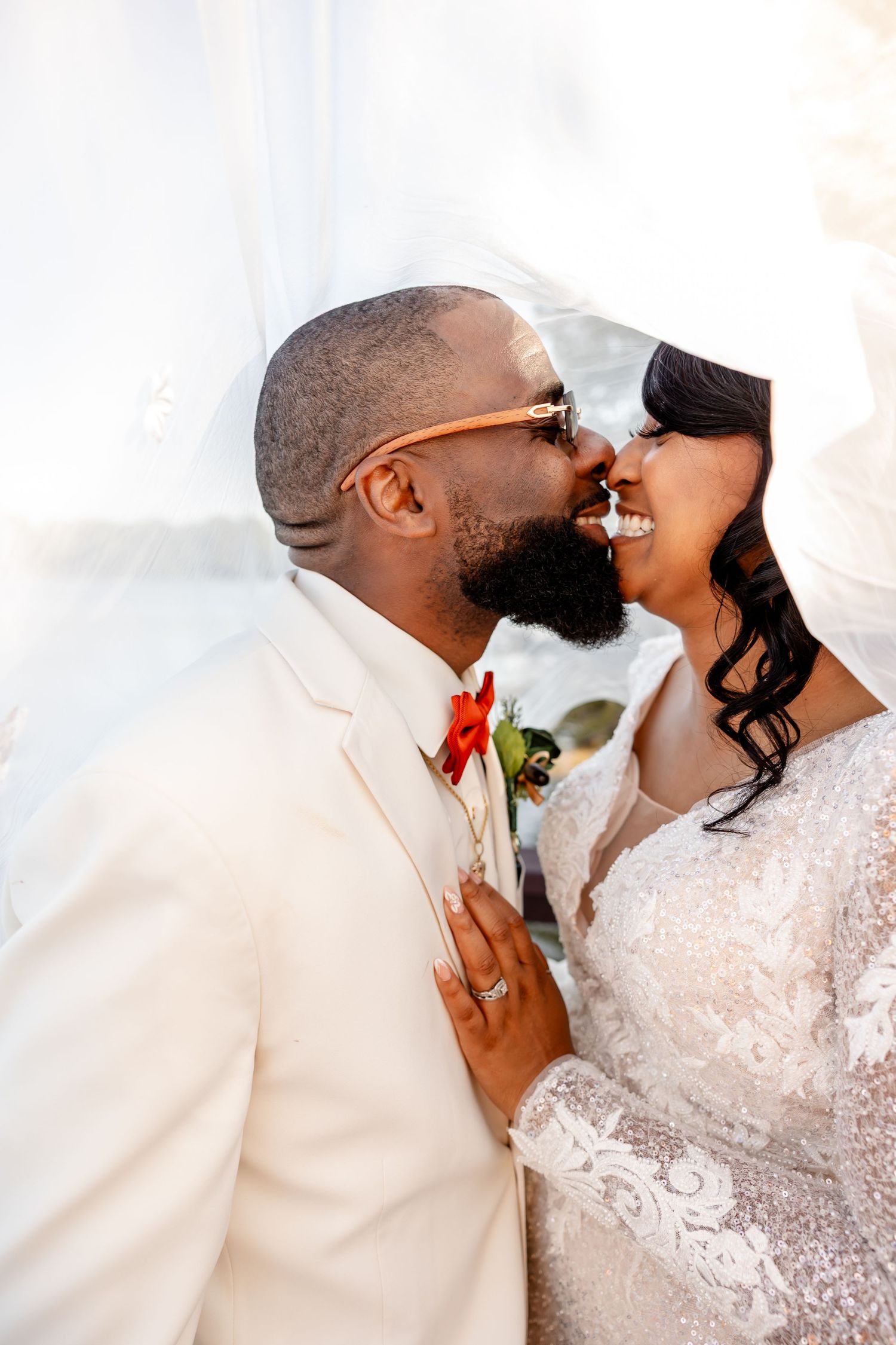 Romantic wedding portrait of couple in white attire sharing intimate moment.
