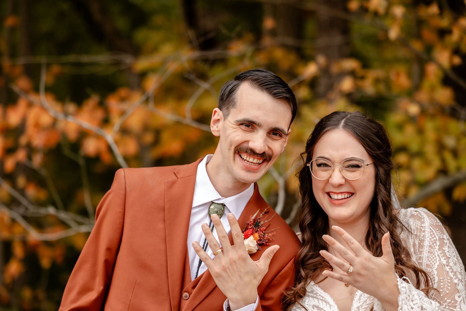 Couple sharing a joyful moment against autumn foliage background.