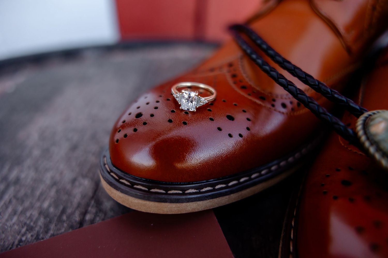 Close-up detail shots of brown leather dress shoes on dark wooden surface.