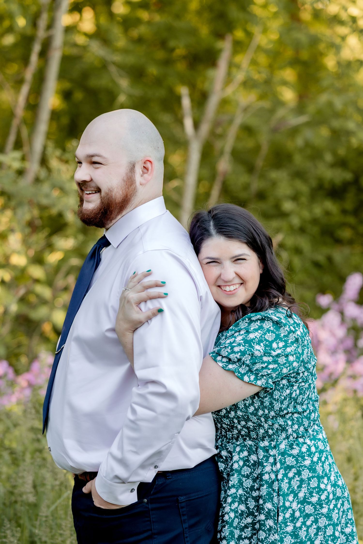 Couple embraces and laughs together in a natural outdoor setting during golden hour.