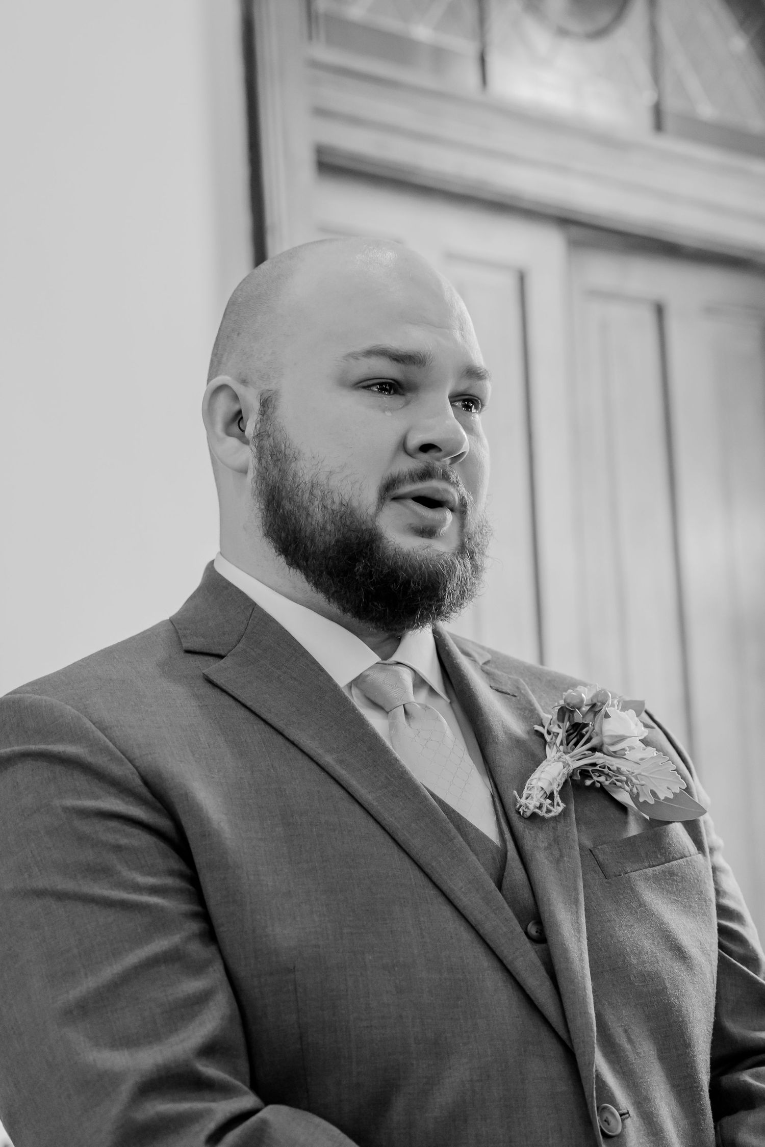 A series of black and white portraits showing a bearded man in a formal suit and boutonniere at different angles.