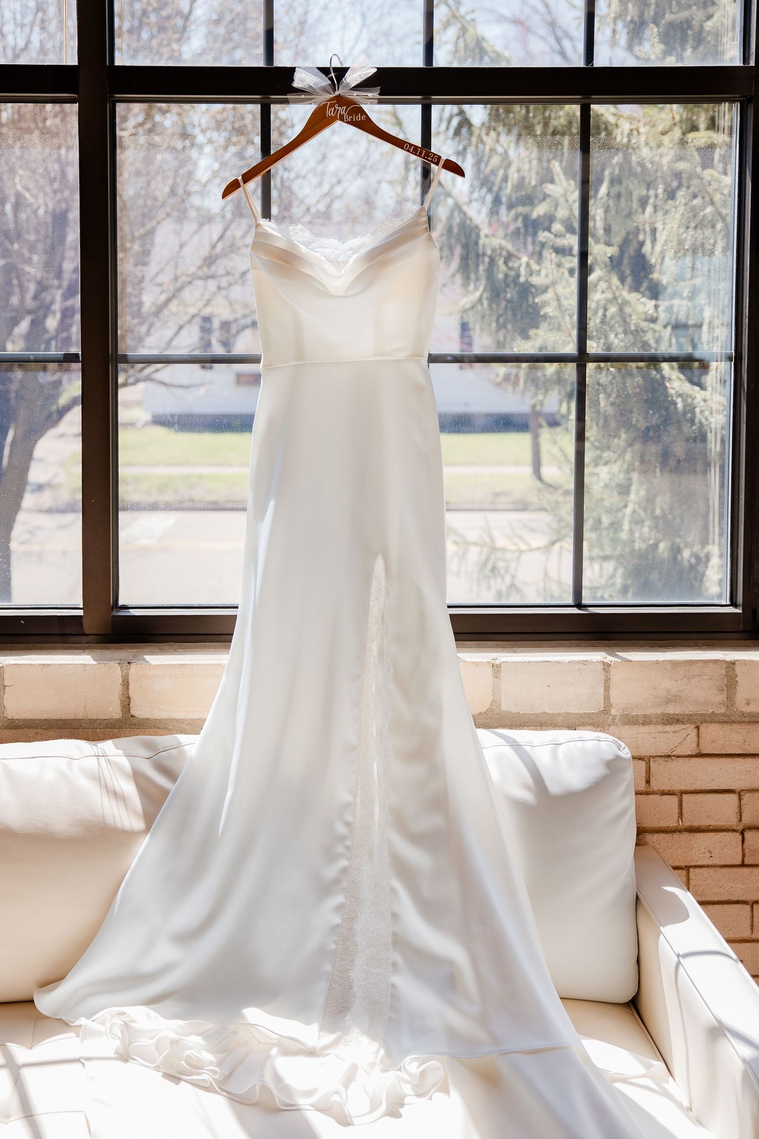 Wedding dress displayed in sequence showing button details against a bright window backdrop.