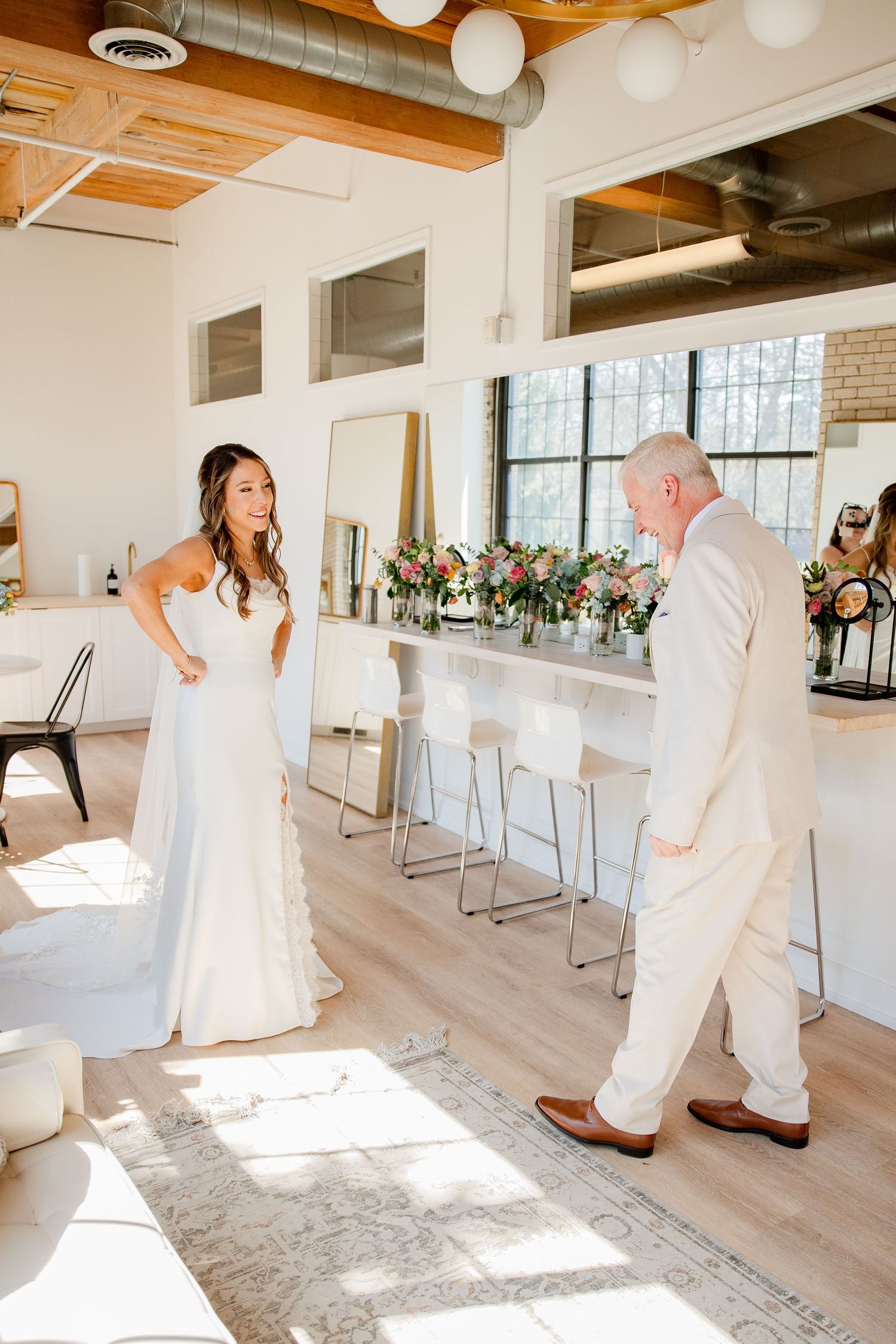 Candid moments of a bride in white dress during wedding preparation in a modern venue.