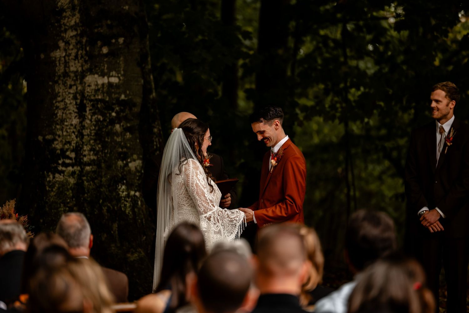 Wedding celebration in a forest setting with warm autumn lighting.