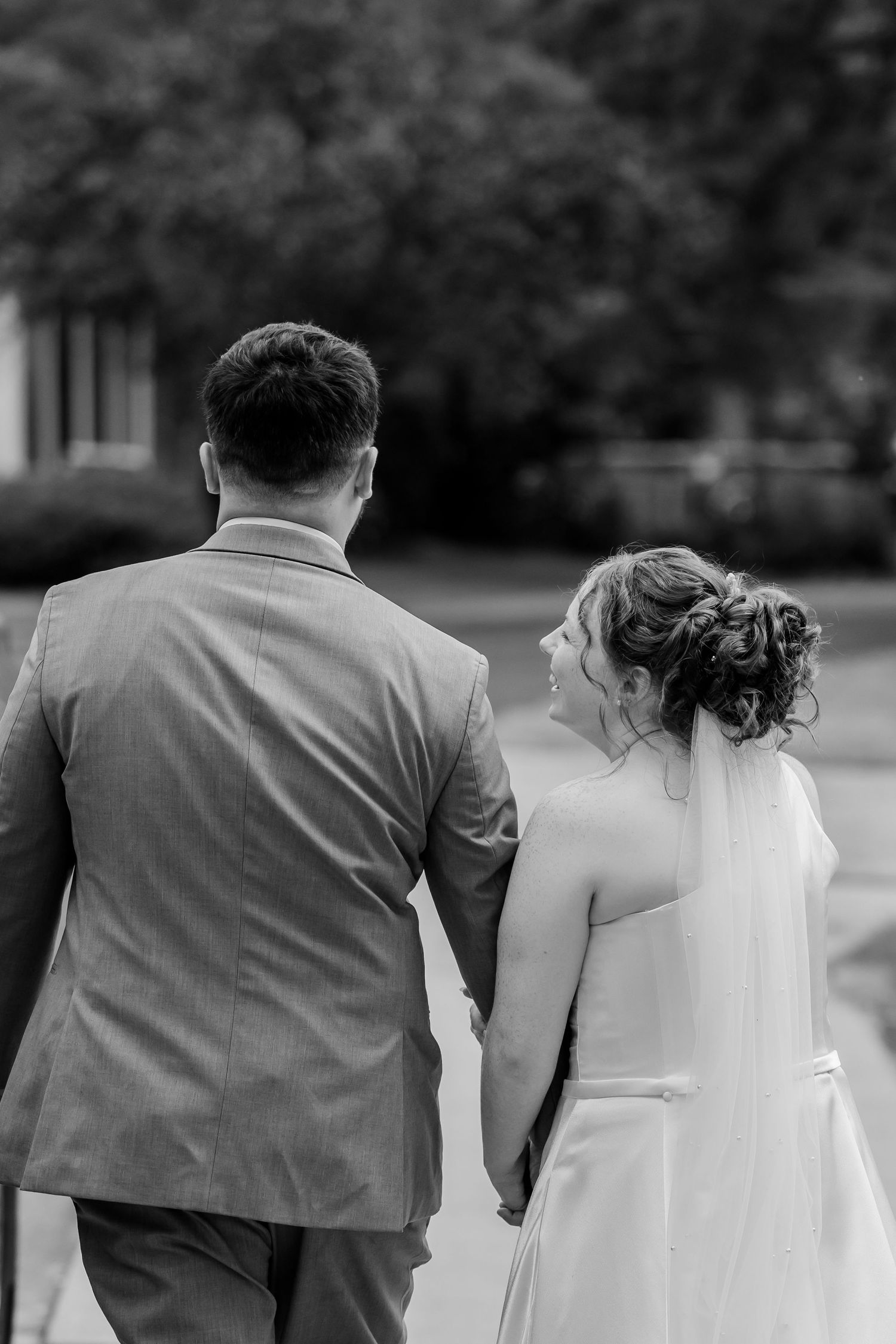 Black and white photo series of a couple walking together in formal wedding attire.