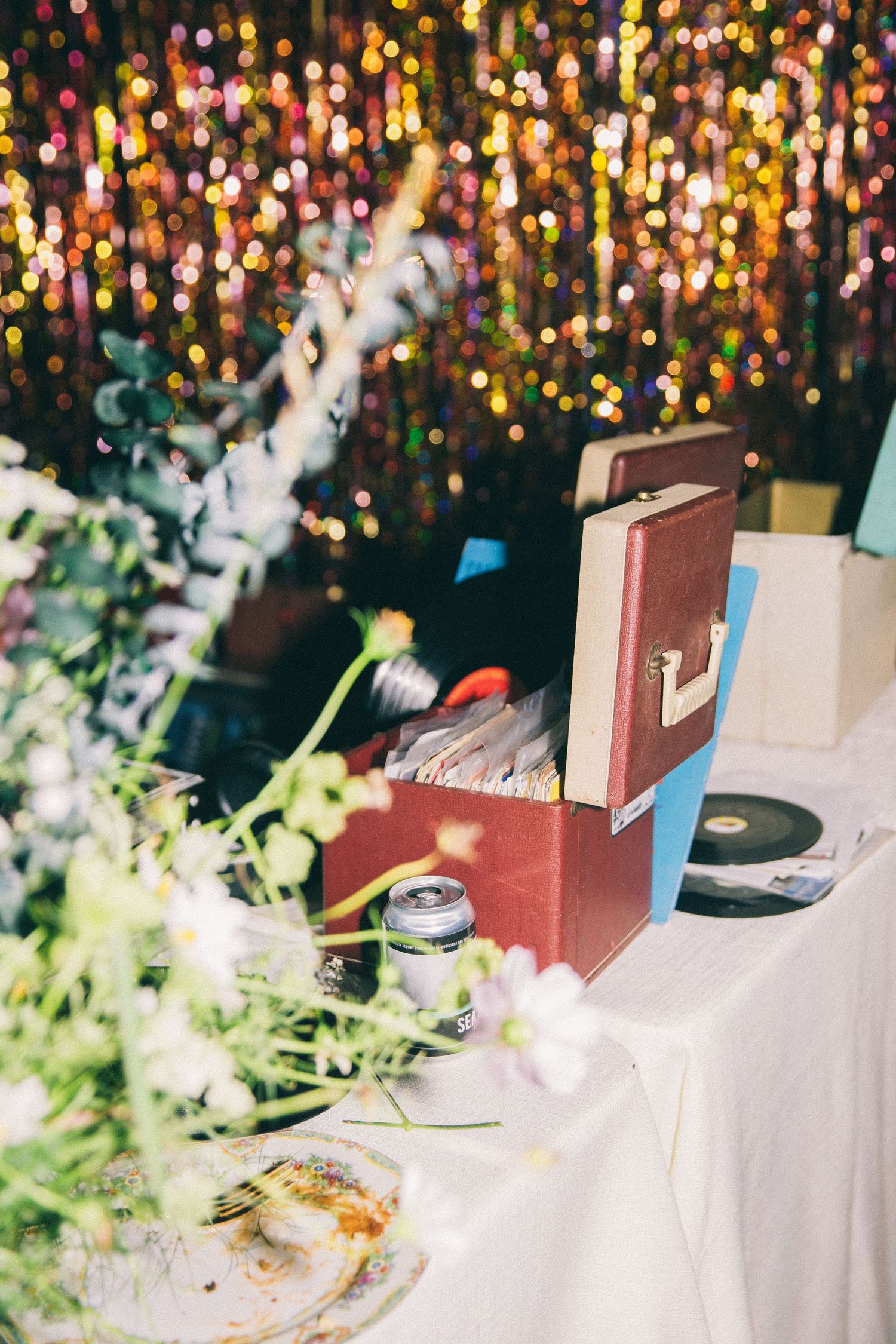 DJ setup at wedding reception with bokeh lights and decorations.